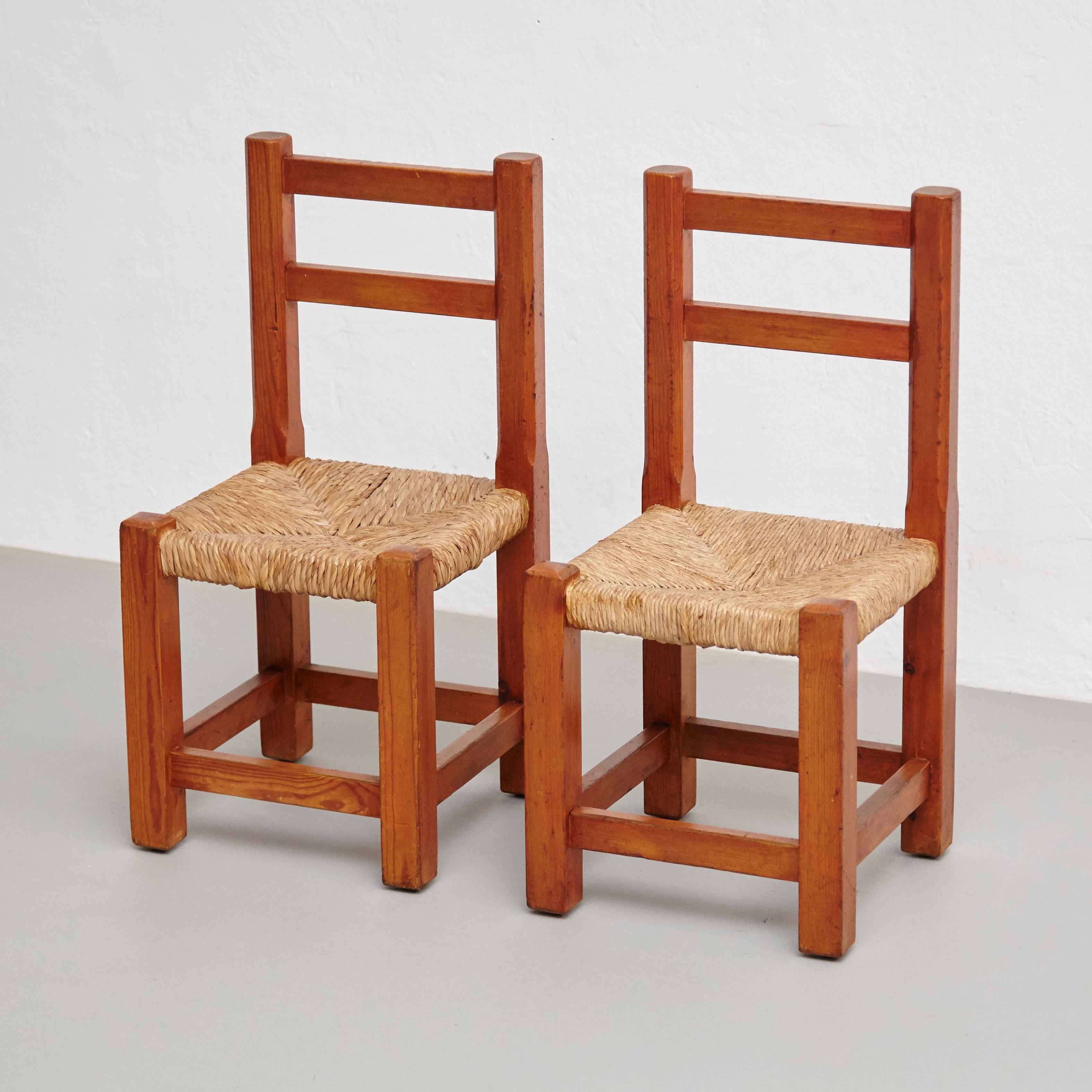 Pair of wood and rattan children chairs.
By unknown manufacturer, France, circa 1960. In original condition, with minor wear consistent with age and use, preserving a beautiful patina.

Materials:
Wood
Rattan

Dimensions:
D 30 cm x W 30 cm x