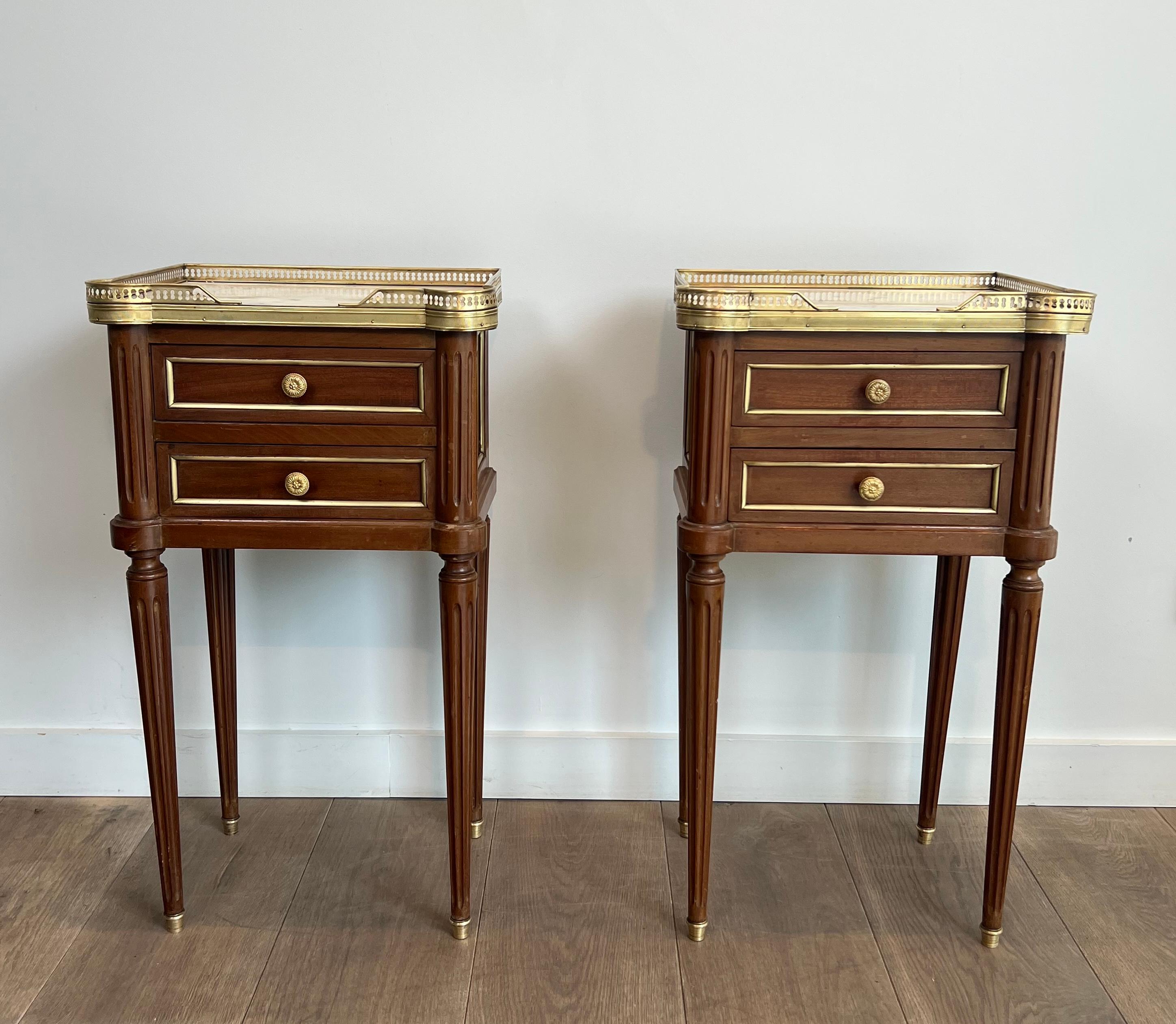 This very nice and elegant pair of side tables or nightstand tables are made of wood and brass with White Carrara marble tops. These side tables or bedside tables have 2 drawers. This is a French work in the style of Maison Jansen. Circa 1940