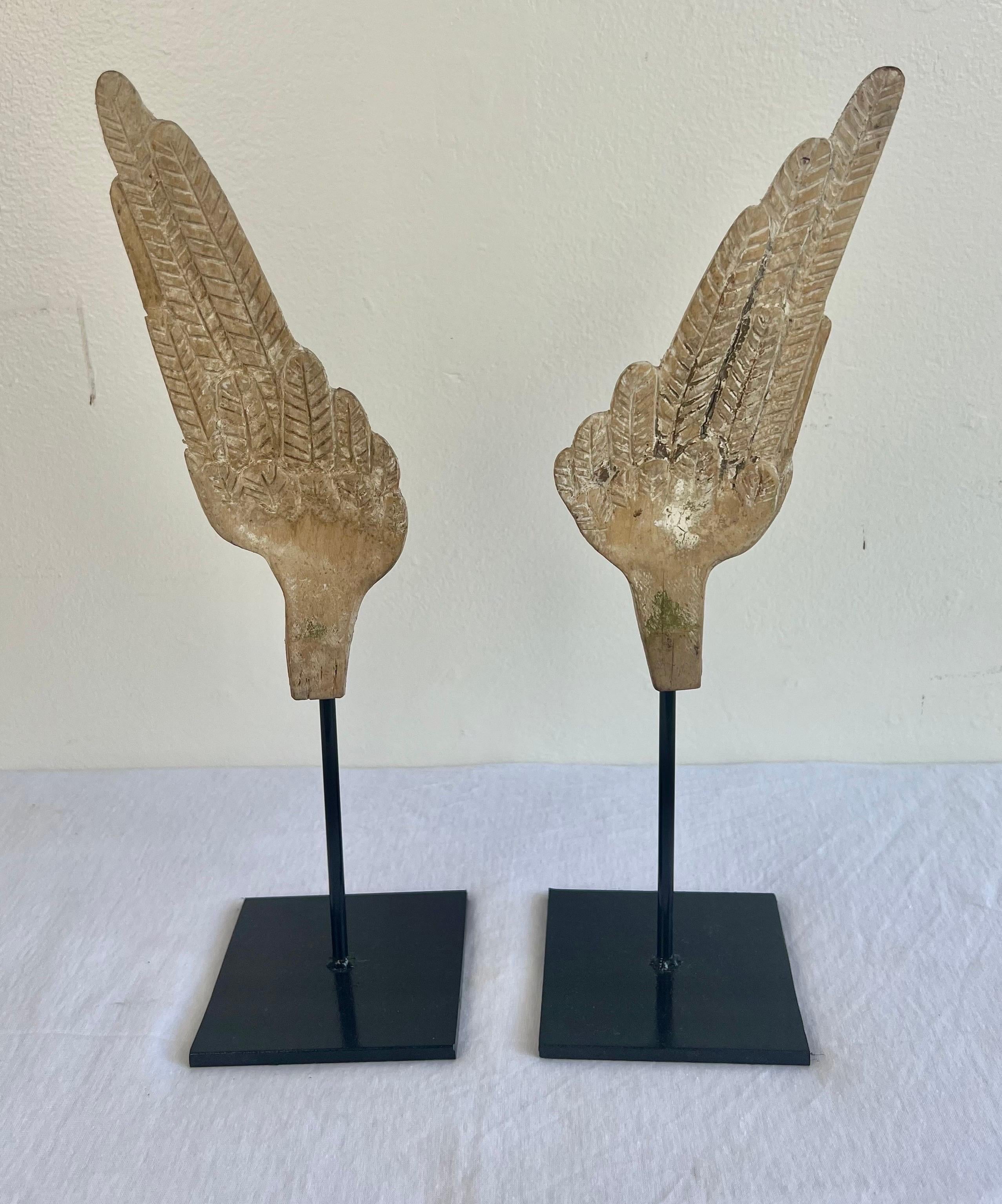 Pair of hand carved wood Italian wings that are newly mounted on iron bases.  Great display items for your bookcase.