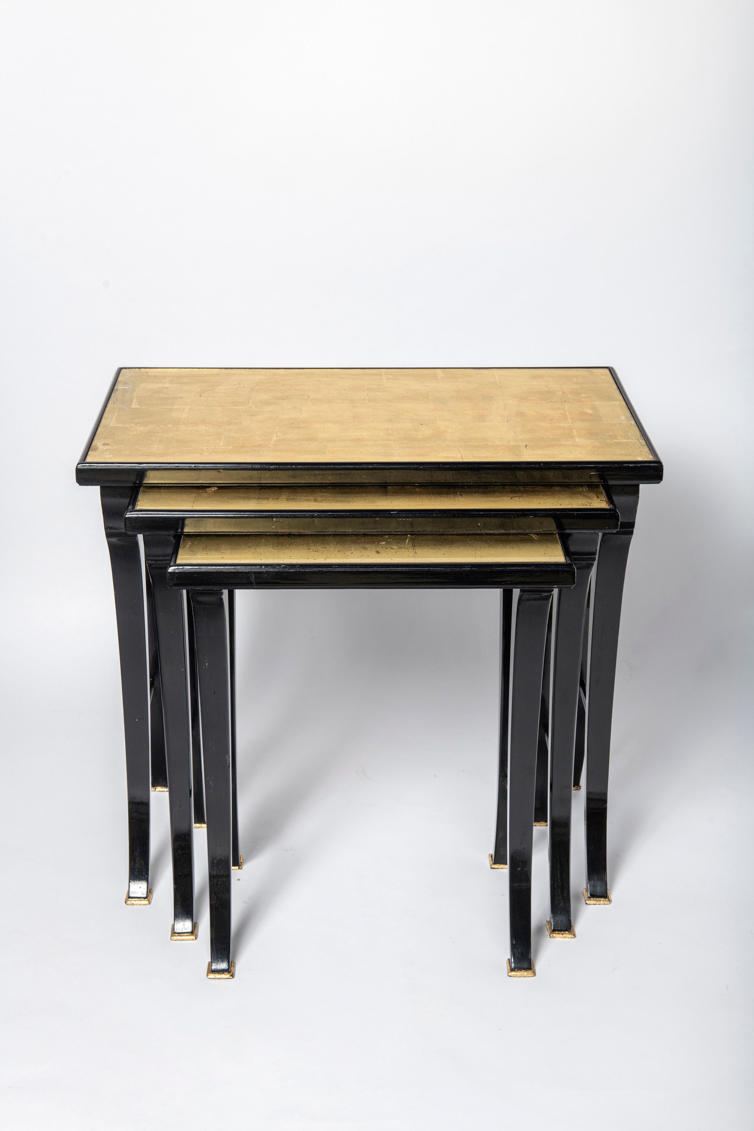 Pair of wood, glass and gold leaf nest tables by Maison Jansen. France, circa 1950.

Dimensions big table: 56 cm height, 61 cm width, 37 cm depth.
Dimensions middle table: 53 cm height, 50 cm width, 36 cm depth.
Dimensions small table: 50 cm height,