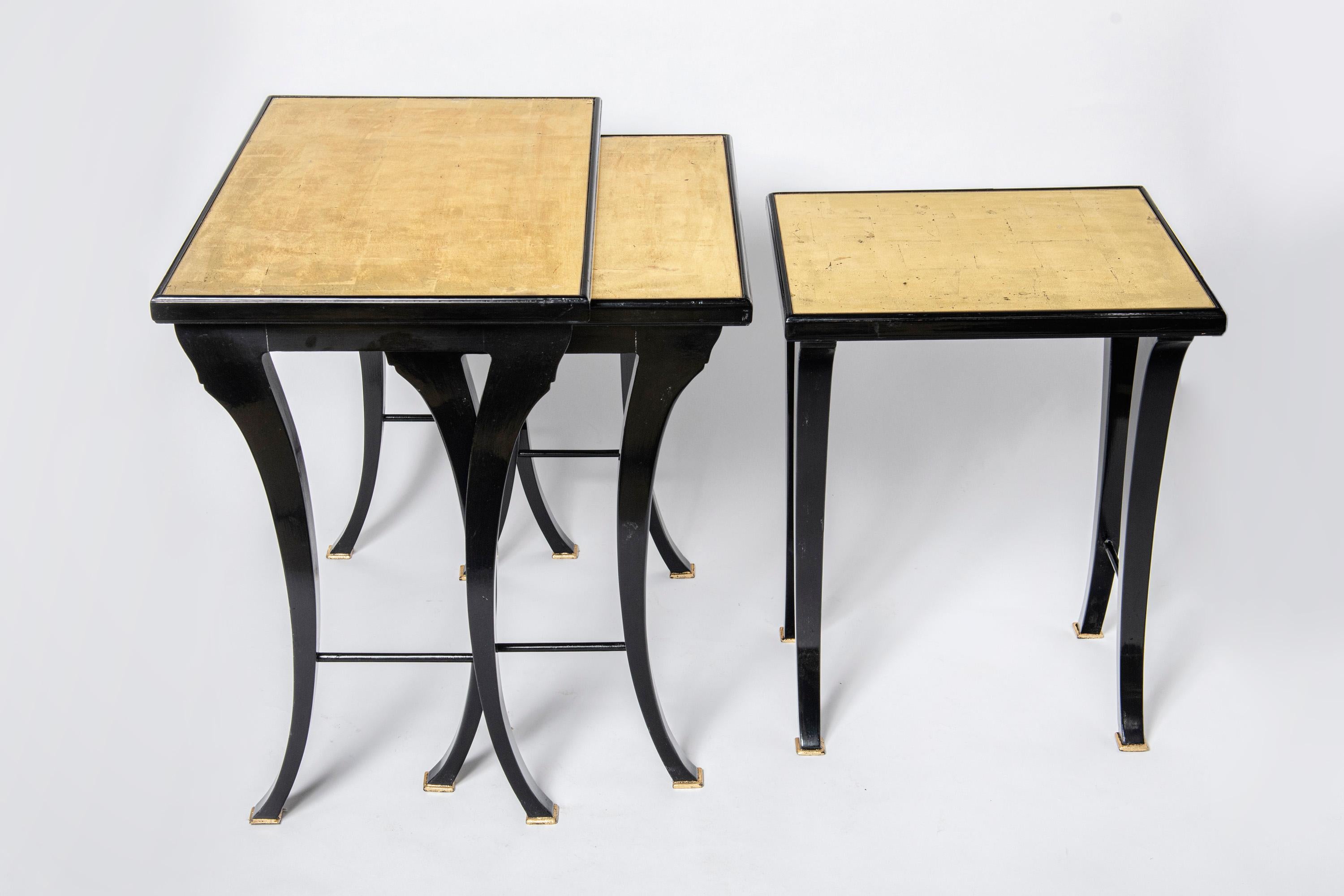 Mid-Century Modern Pair of wood, glass and gold leaf nest tables by Maison Jansen. France, c. 1950. For Sale