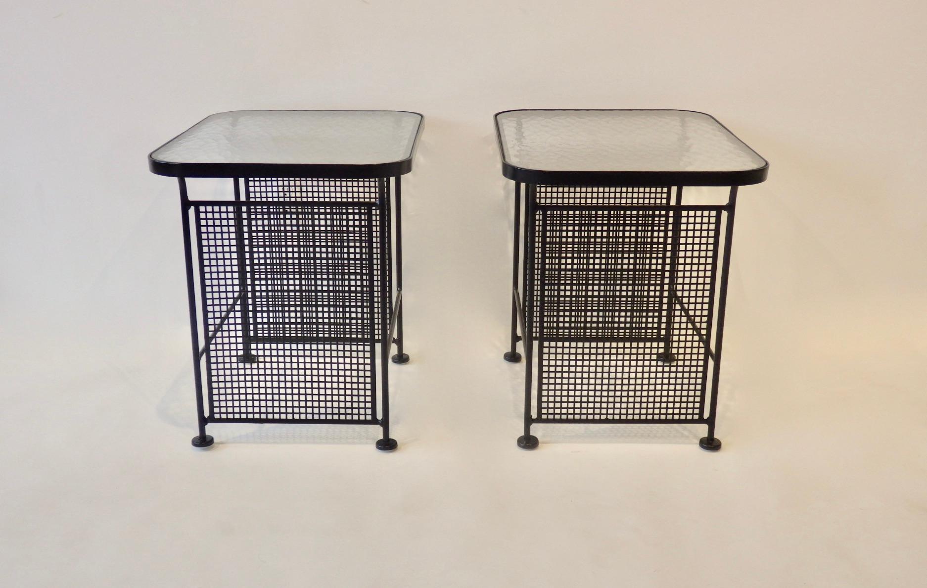 Pair of Woodard glass top tables with wrought iron and mesh steel base. Recently powder coated in matte black finish. New glides added to feet.