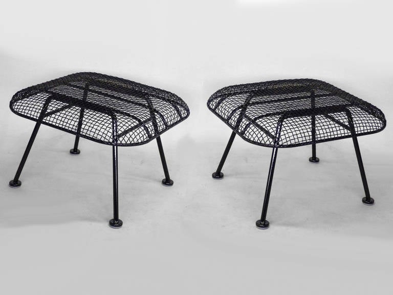 John Woodard for Woodard steel mesh over wrought iron ottomans. Made to work with the large Woodard lounge chairs or as stools. Beautifully restored in gloss black powder coat.