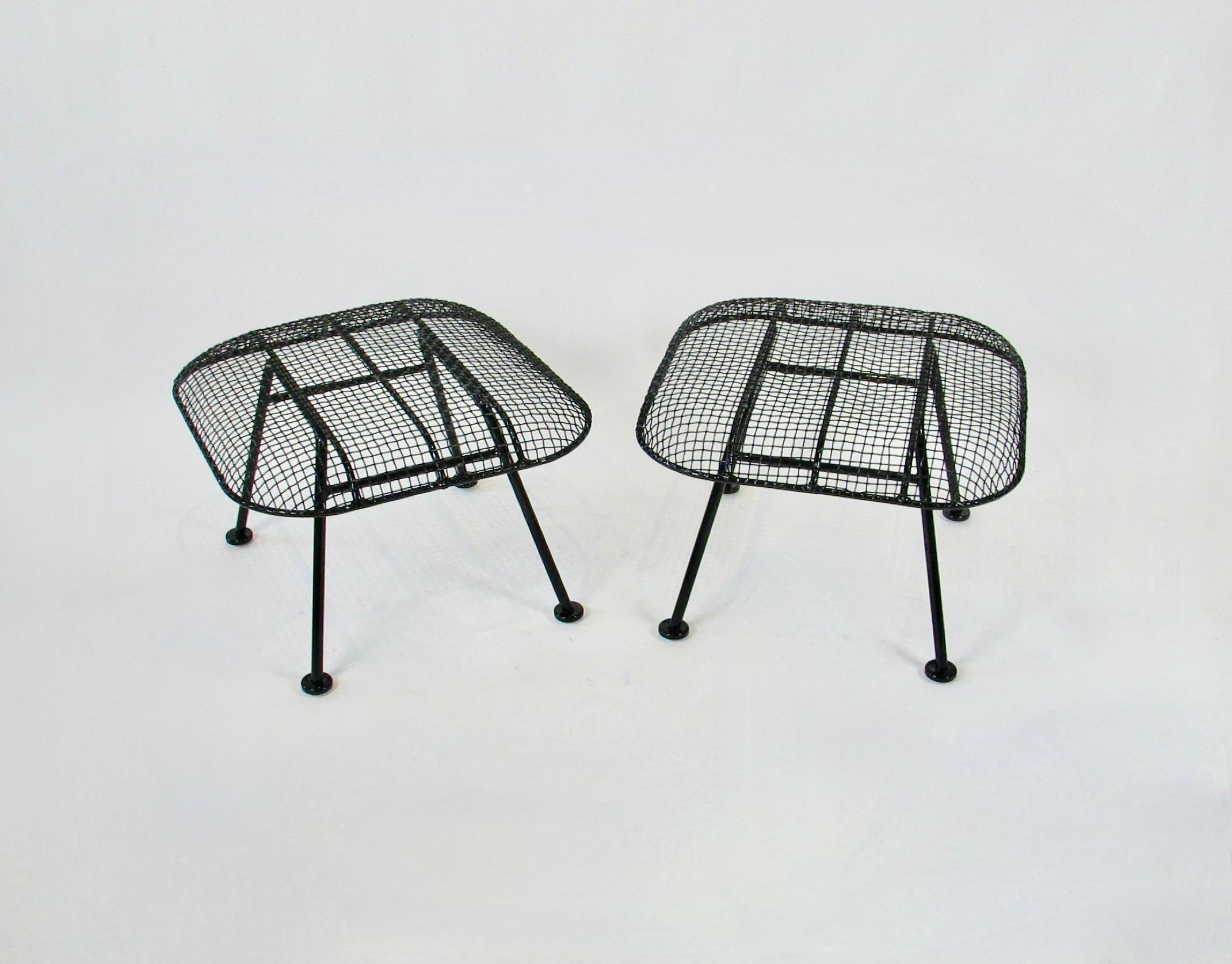 Pair of Woodard steel mesh over wrought iron ottomans. Part of the Woodard Sculpture series. Designed to work with the large Woodard lounge chairs as ottomans stools or side tables. Beautifully restored in gloss black powder coat. New glides added