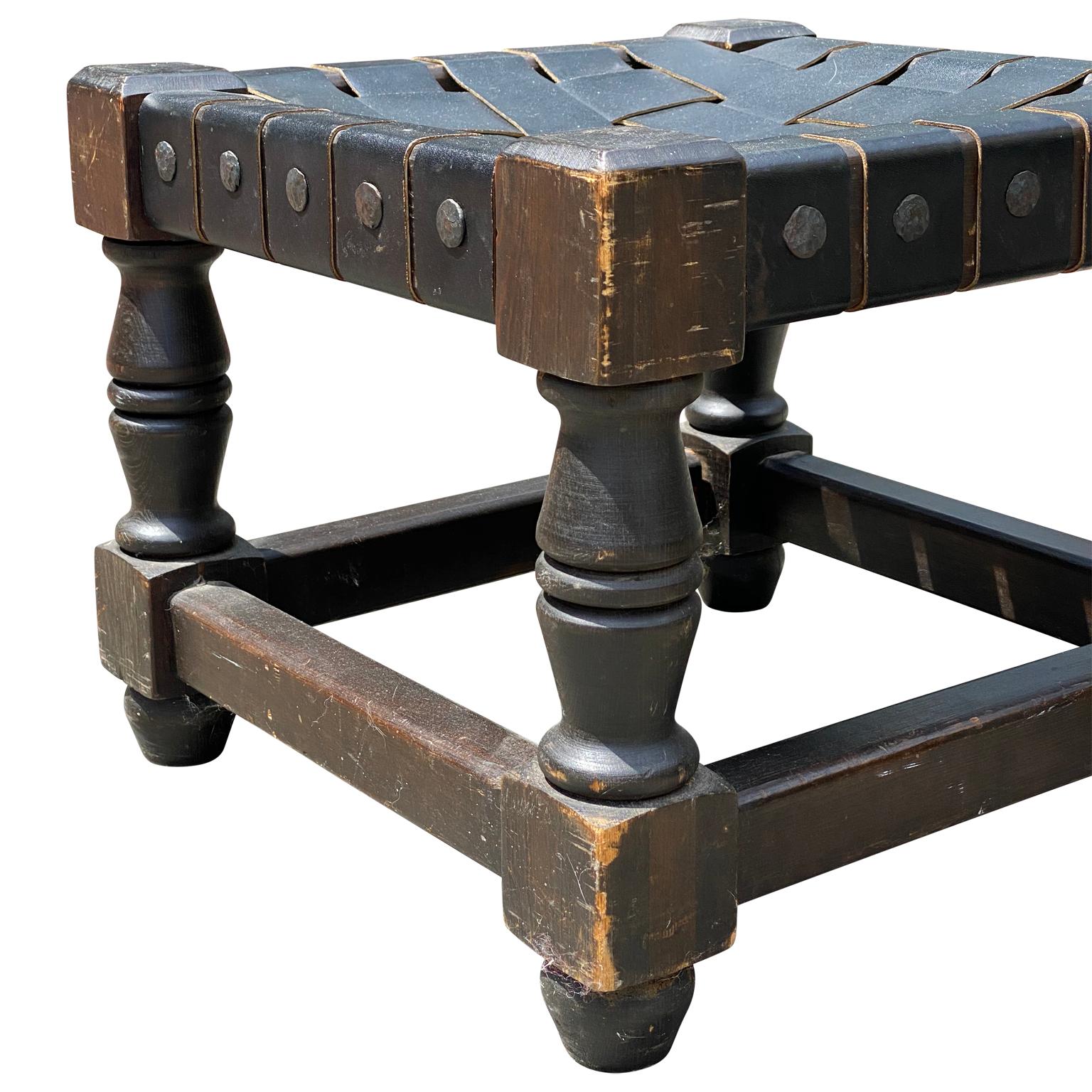 Pair of American rustic stools with black leather folded upholstery

The low stools have large metal nails on the side as hardware.
 