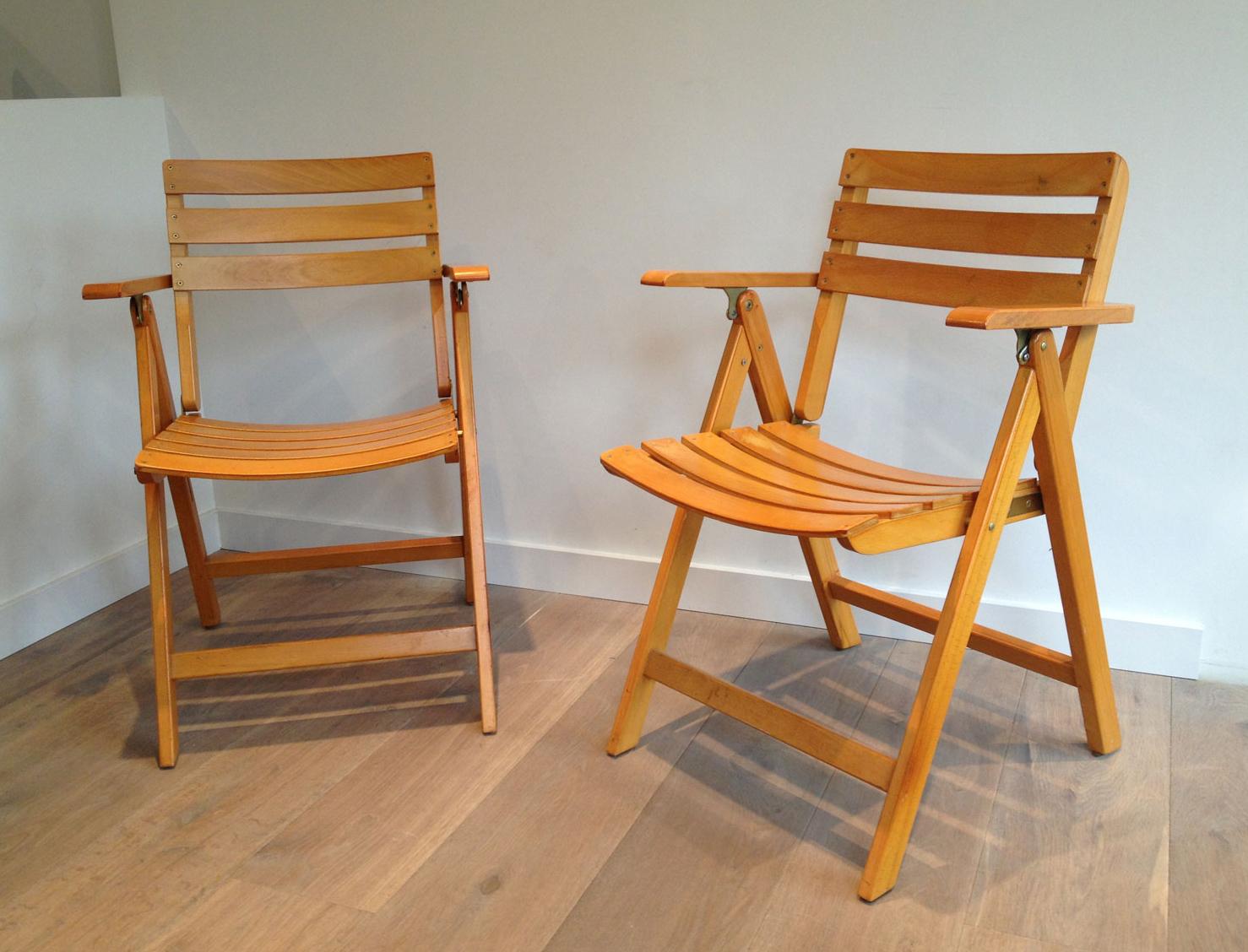 Cette paire de fauteuils pliants est fabriquée en bois verni. Il s'agit d'une œuvre française signée Clairitex. Circa 1970.
