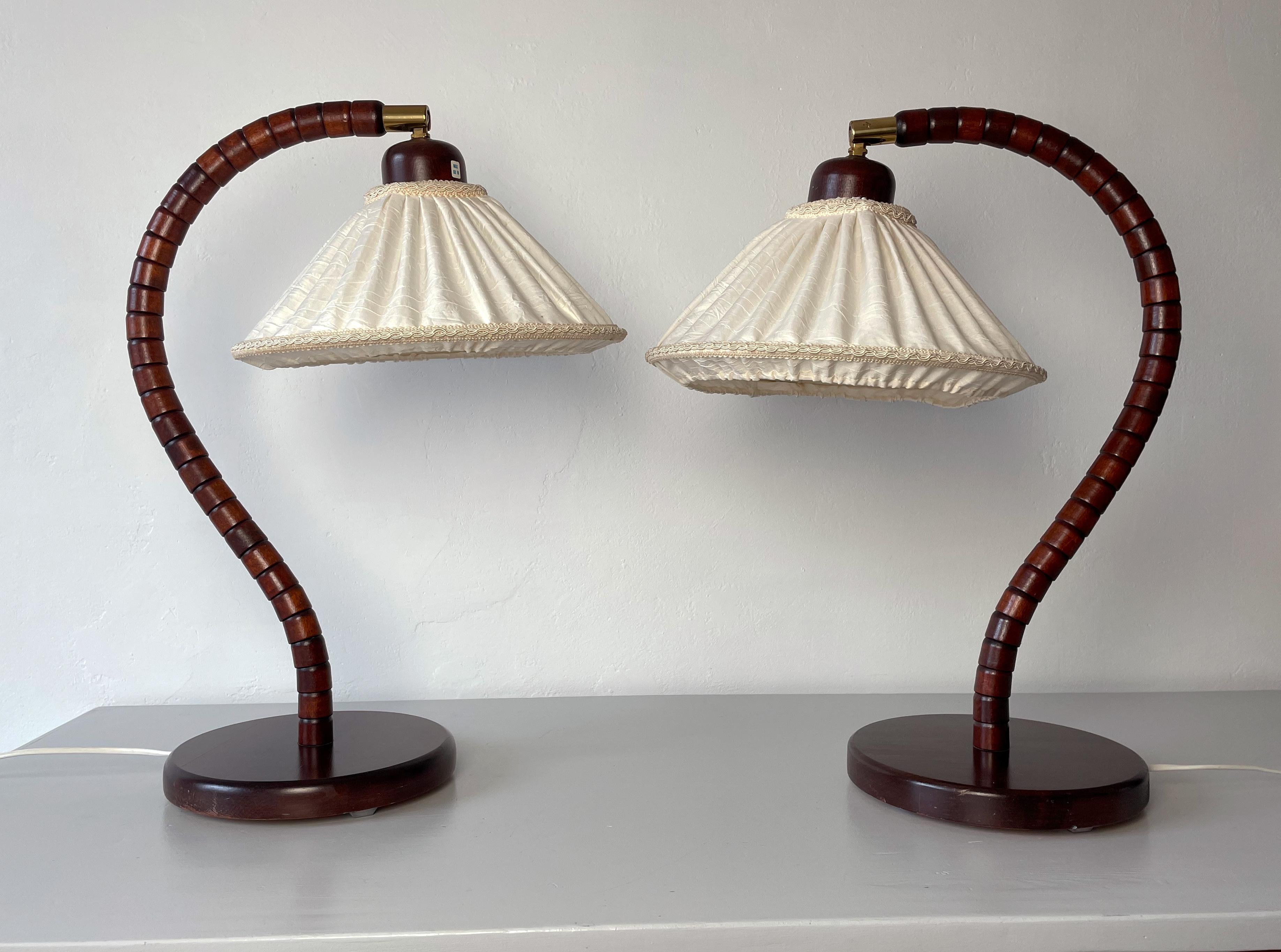 Sculptural set of table lamps produced by Markslöjd in Sweden in the 1960s. Organically shaped and made of tiers of solid beech wood in the shape of a large question mark placed on a solid circular base. Dark cherry, mahogany colored lacquer.