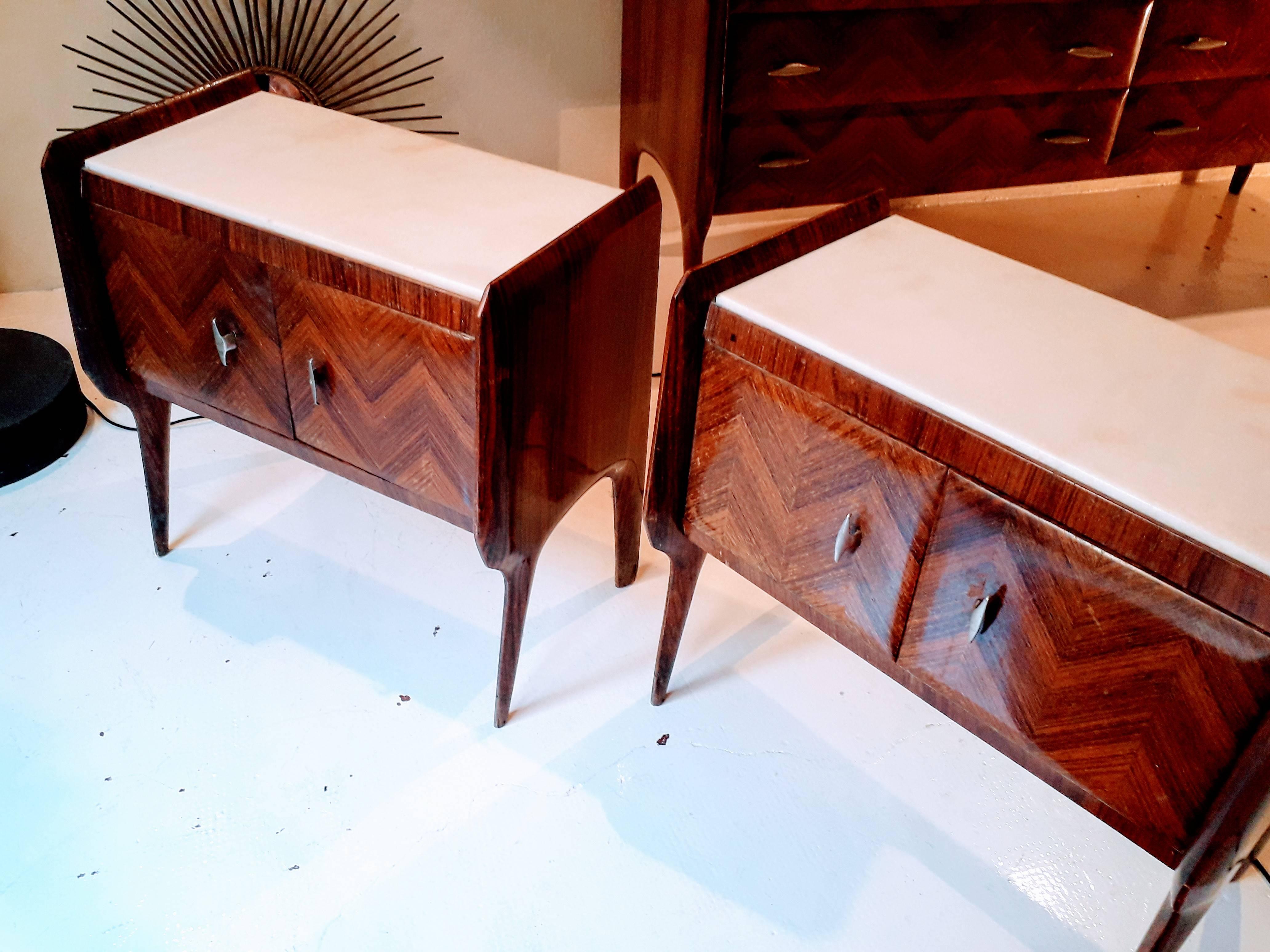 Pair of wooden bedside tables, designer Vittorio Dassi, Italy, 1950.
Wood, top of white and pink marble, fishing flower, the handles in golden brass.
The tables are all original. To notice the whole design of the side from which the legs depart.
 