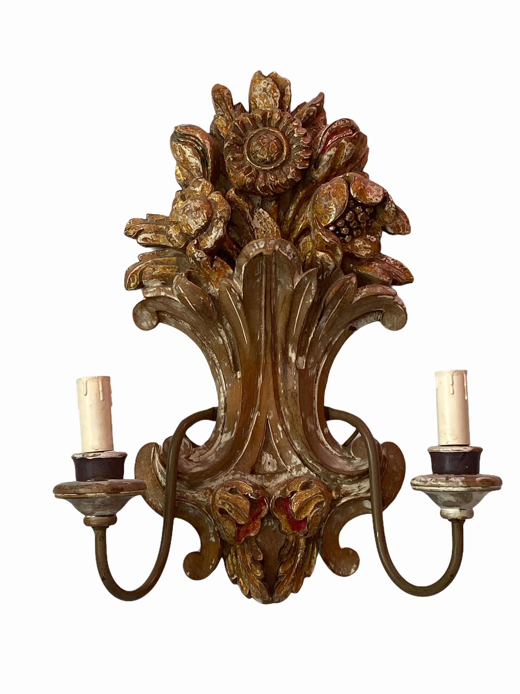 Add a touch of opulence to your home with this charming pair of sconces. Perfect gilt, chippy white and hand carved wood to enhance any chic or eclectic home. We'd love to see it hanging in an entryway as a charming welcome home. Built in the 1940s,