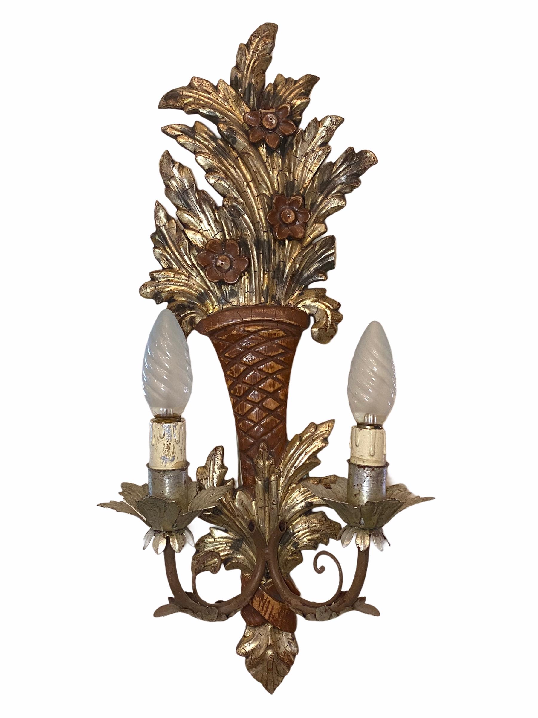 Add a touch of opulence to your home with this charming pair of sconces. Perfect silver gilt and hand carved wood to enhance any chic or eclectic home. We'd love to see it hanging in an entryway as a charming welcome home. Built in the 1920s, in