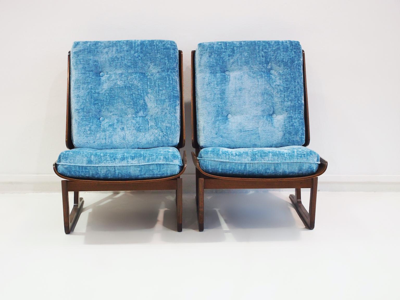 Ein Paar Sessel aus den 1950er Jahren. Bemerkenswert ist die Rückenlehne der Stühle, die aus einem einzigen Holzblock besteht, der das Kissen umschließt. Das gleiche Design wird für den Sitz verwendet. Einige haben das Design der dänischen