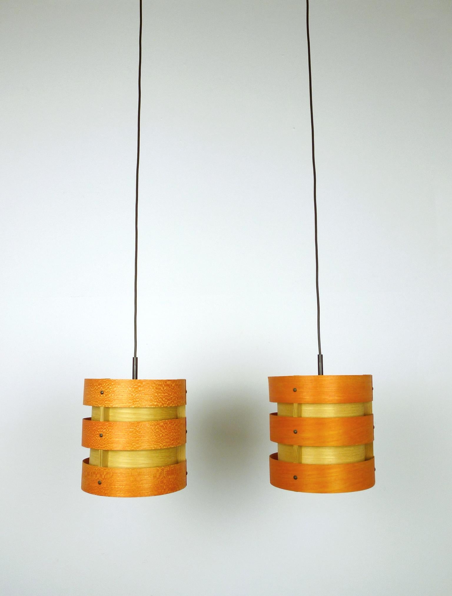 Set of two ceiling lights from the German manufacturer Zicoli from the 1970s. The lights consist of five overlapping veneer strips of ash wood, which are connected by narrow pine wood strips. The three outer rings are stained in orange. They are