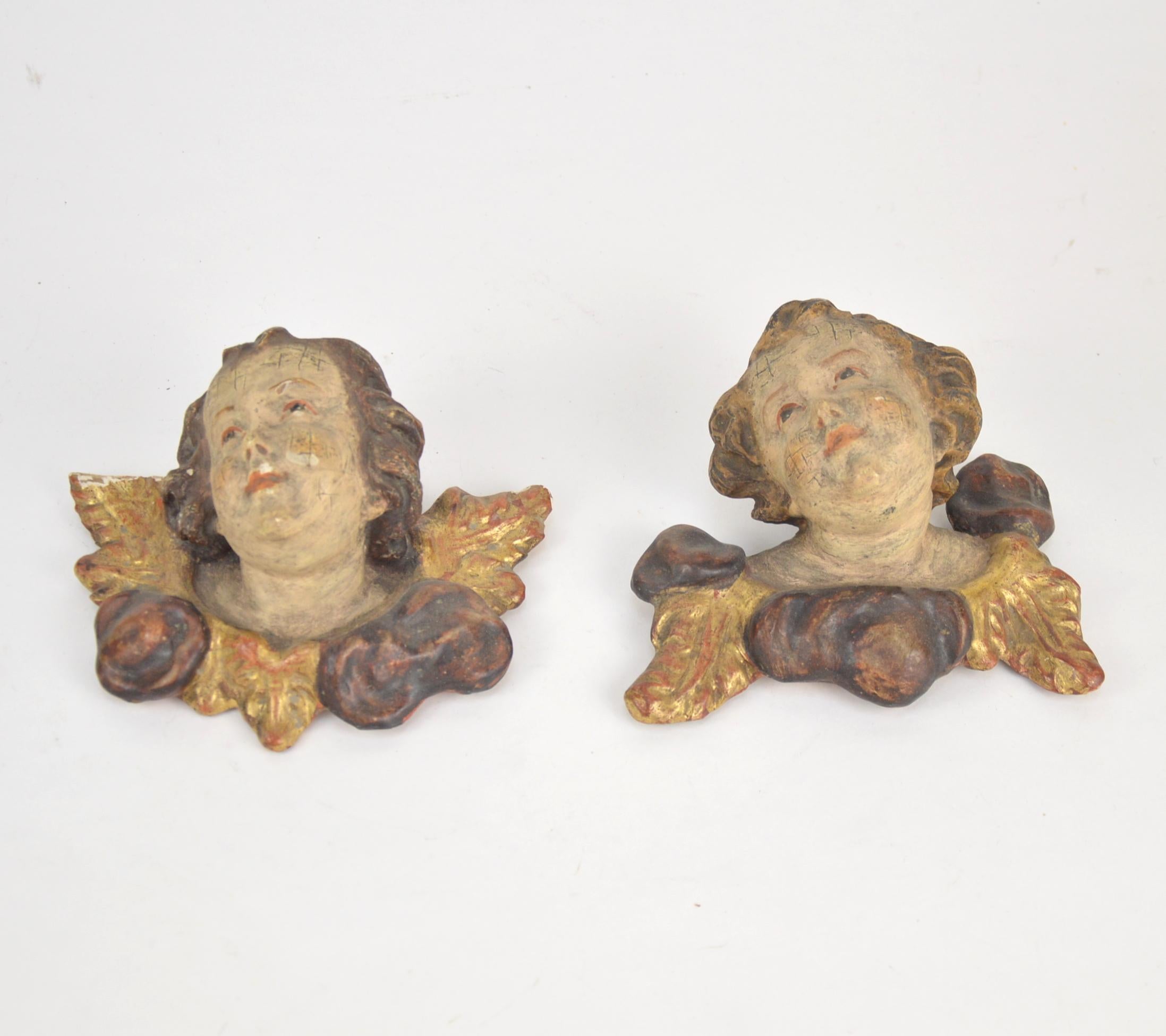 Pair of wooden wall-mounted sculptures representing angel heads, 19th century. Probably France.