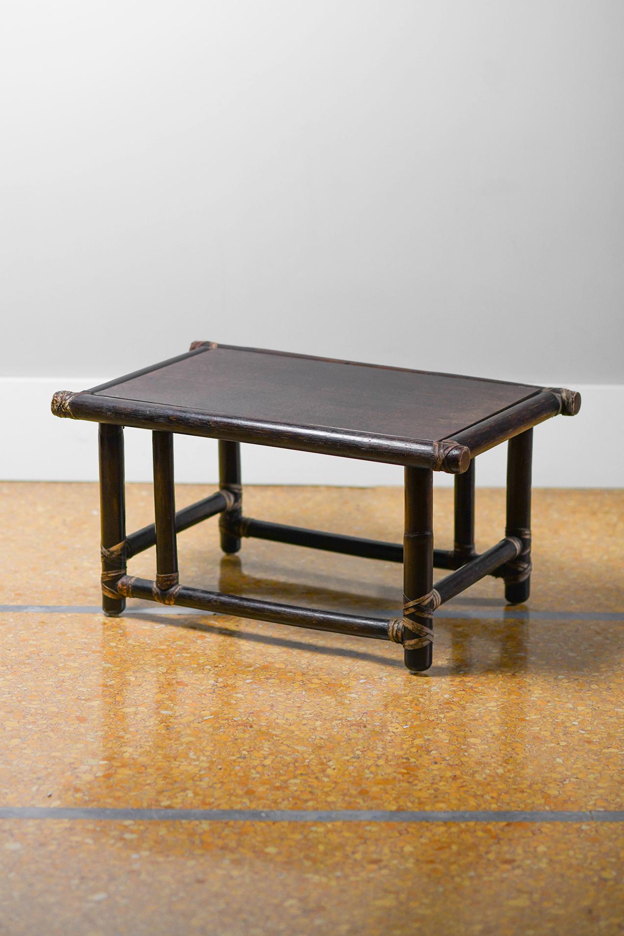 Pair of wooden tables (Dark finish) with leather bindings 
Production: Lyda Levi - McGuire 
Single table dimensions 65 W x 35 H x 43 D cm
Sold as set of 2