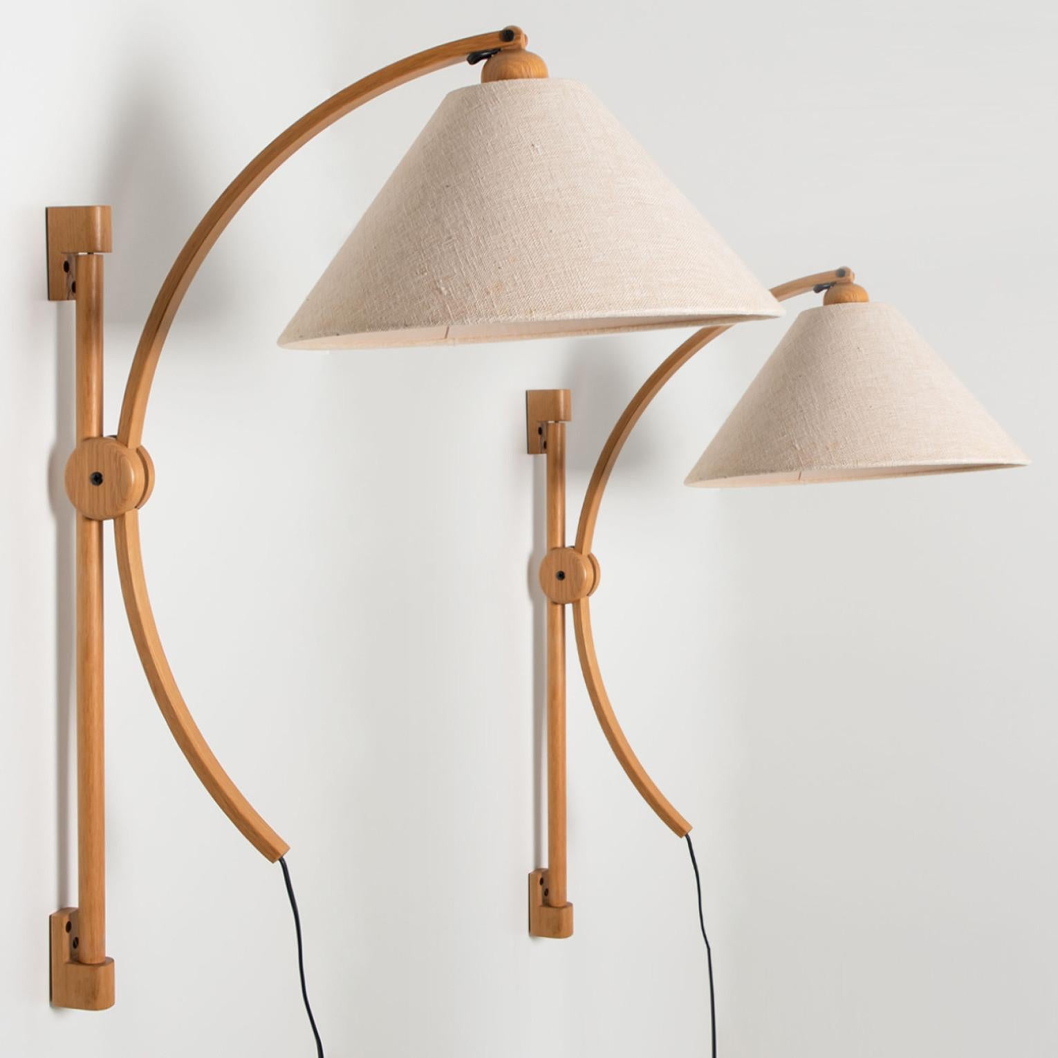 Pair of onderful oak wall lights with a natural toned original lampshade. Manufactured by Domus in the 1970s in Germany, Europe.
The oak base is adjustable in height. The original natural lampshade diffuses a warm light.

