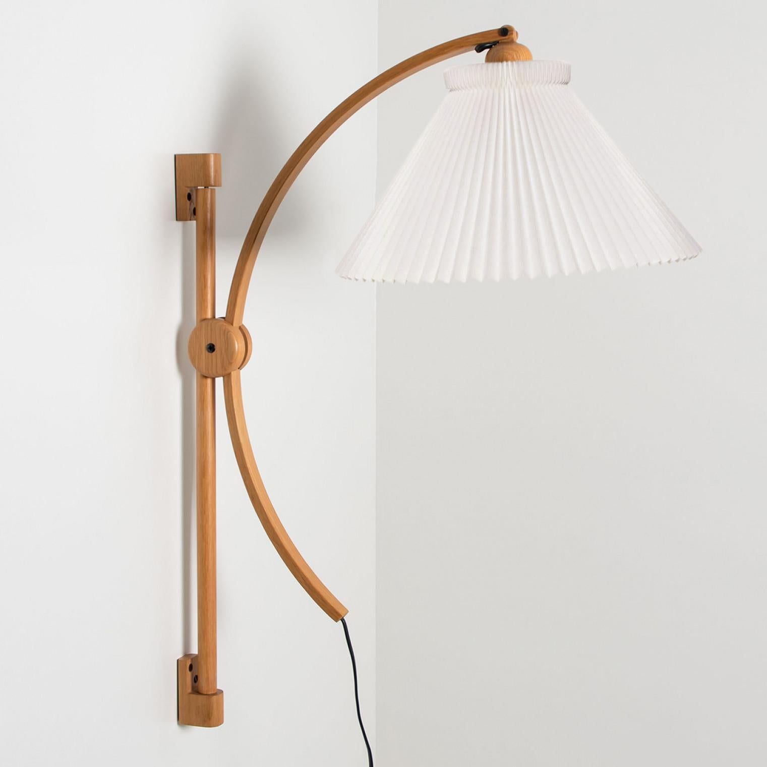 Pair of wonderful oak wall lights with new lampshade by Le Klint. The light is manufactured by Domus in the 1970s in Germany, Europe.
The oak base is adjustable in height. The beautiful, folded lampshade diffuses a warm light.

