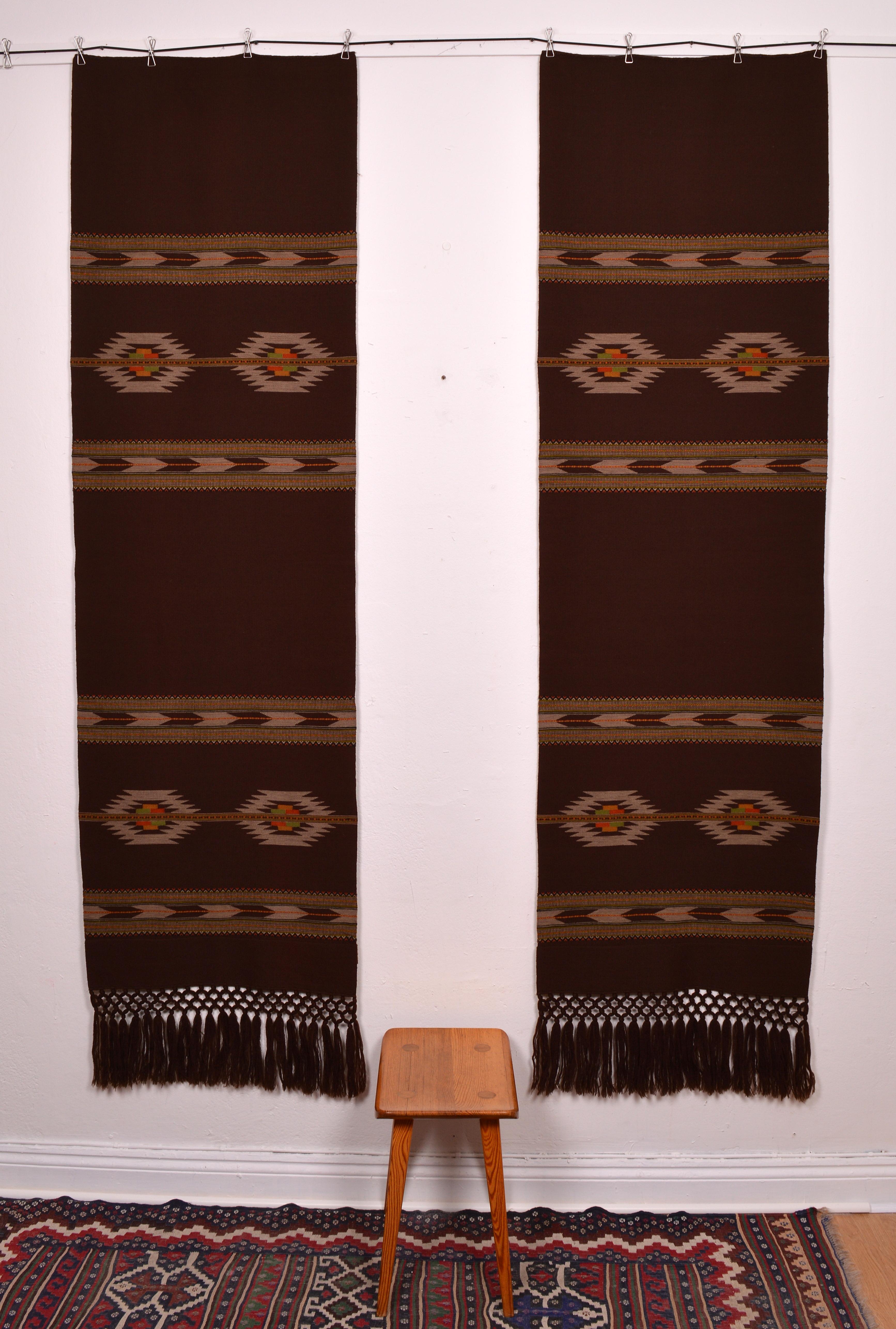 Beautiful pair of chocolate brown wall tapestry with a geometrical design in several colors, woven with wool on cotton. Very good vintage condition only slight traces of use. Dimensions includes the fringes.
 