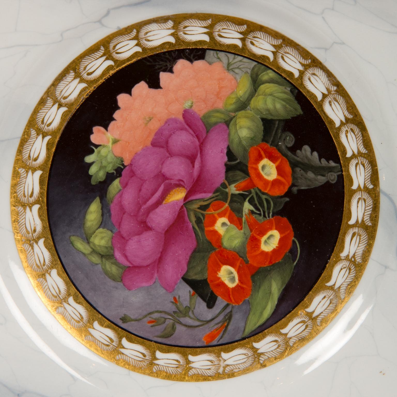 We are delighted to present this pair of Worcester plates with bright hand-painted flowers set against a dark purple ground in the center of each plate. Made circa 1810 they show freesia, a pink rose, a purple peony, peach-colored dahlias, and other