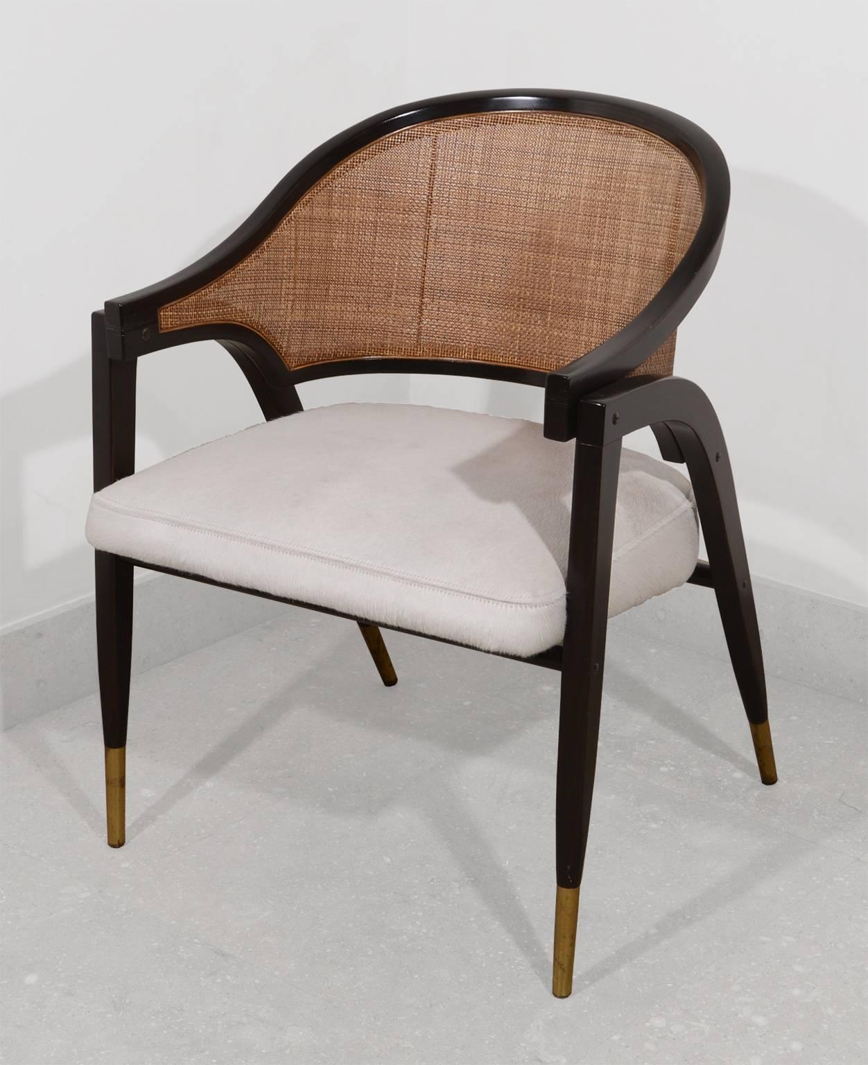 Cane back armchair with laminated ash frame. Brass sabots.