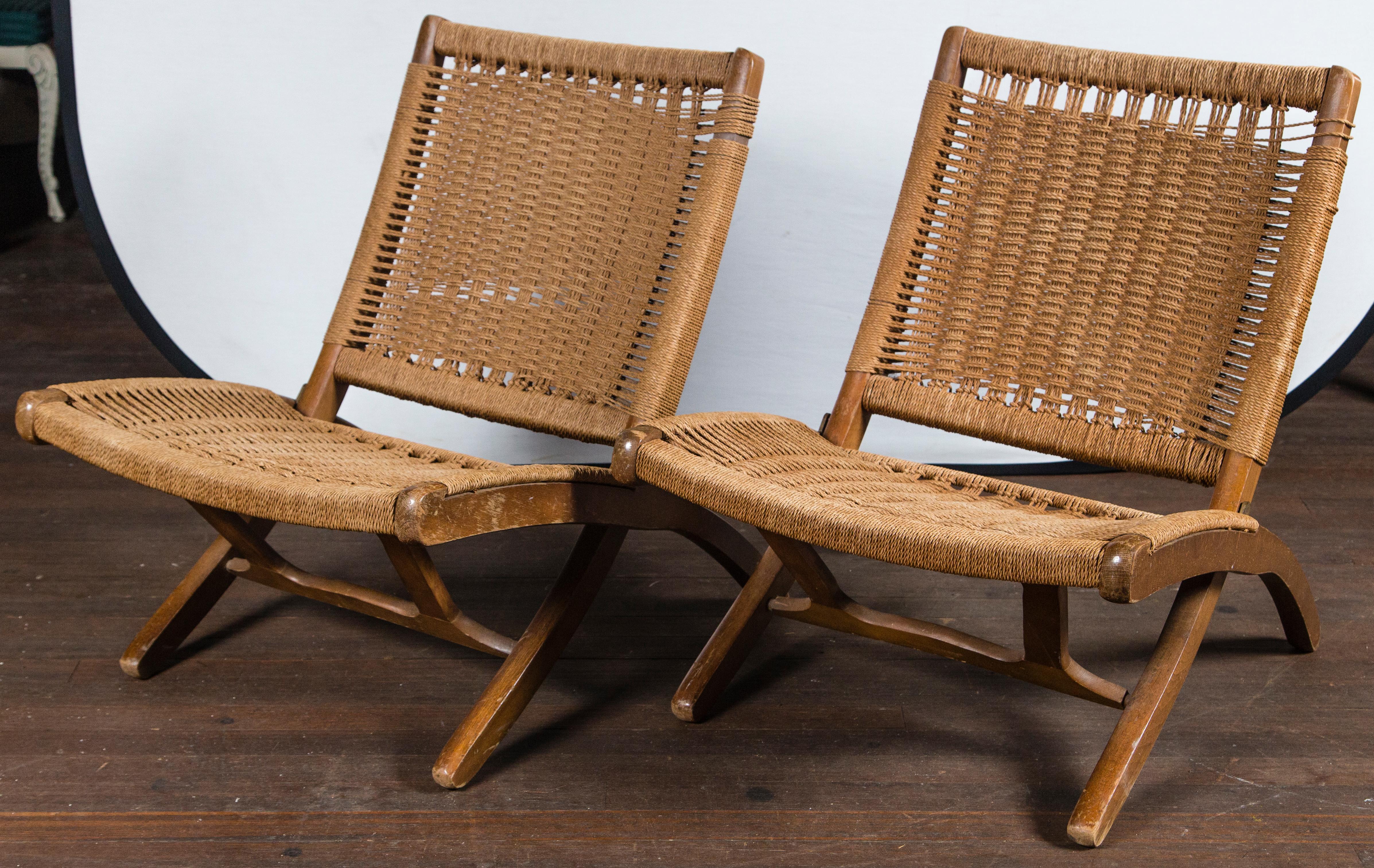 Pair of strong natural fiber woven and wood folding chairs. It the style of Hans Wegner.