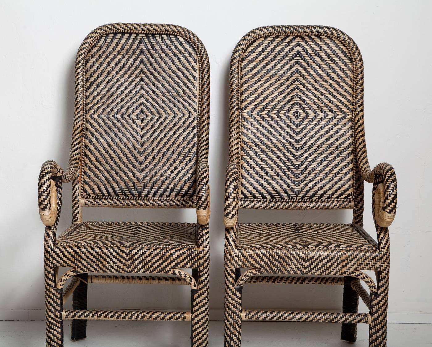 Graphic patterns, natural materials and pleasing design go into this arresting pair of rattan armchairs, handwoven in the Philippines, circa 1980. Very good condition. Sturdy with no losses or breaks to the rattan.