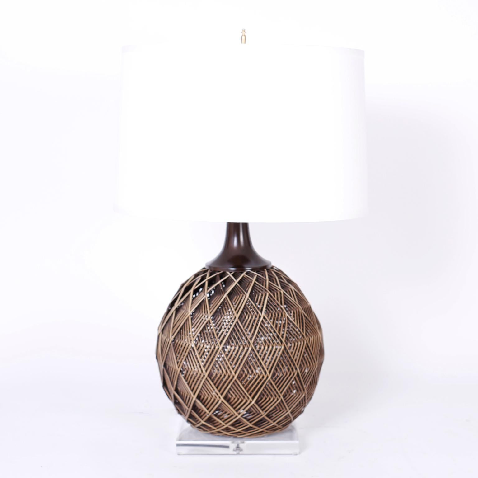 Pair of midcentury table lamps with an ingenious multi-layer geometric woven rattan technique that creates sculptural and emotional depth and presented on Lucite bases.