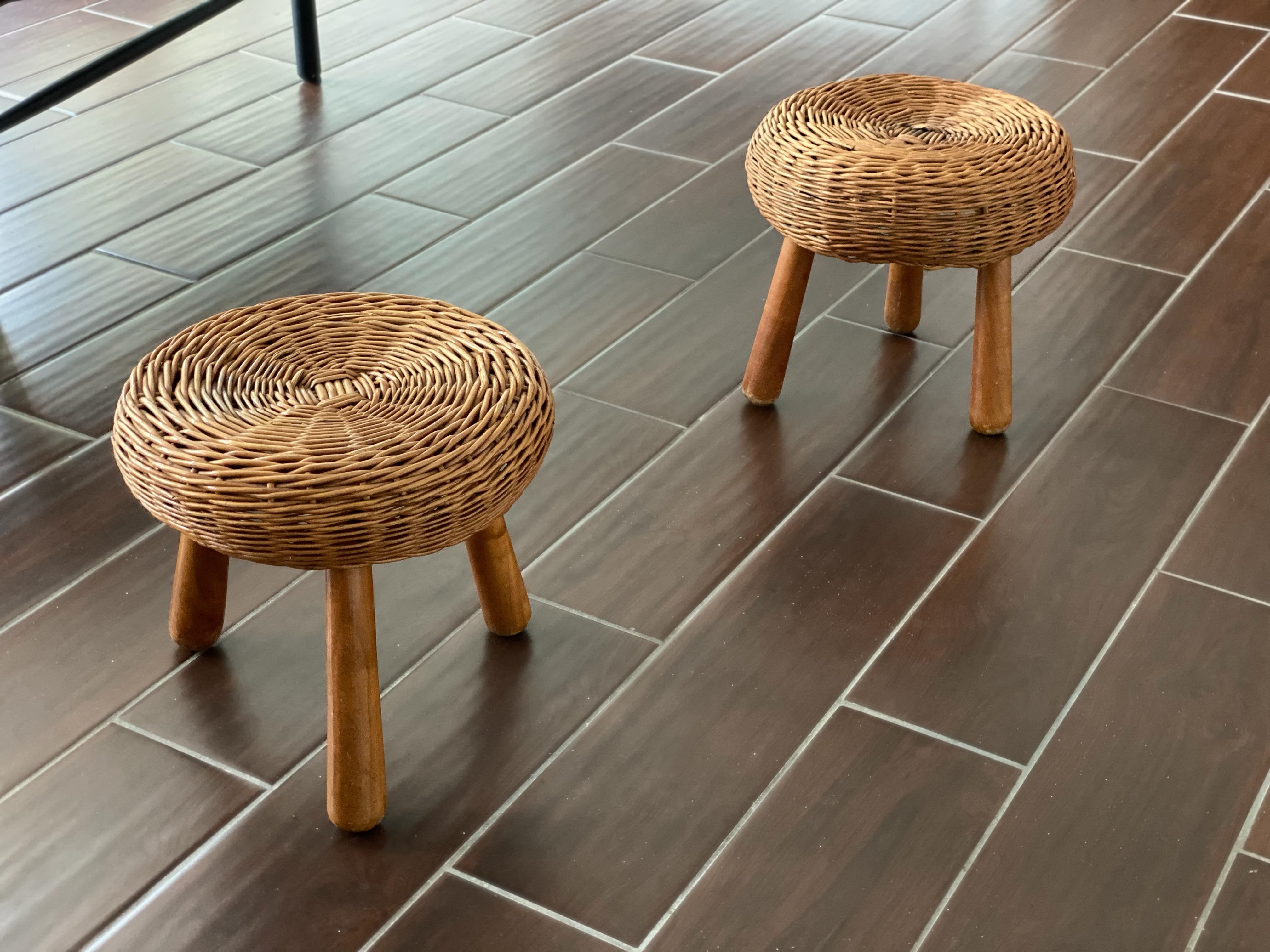 Pair of woven rattan/wicker stools or tables attributed to Tony Paul. Designed utilizing a mix of woven rattan while sitting on top of solid wood legs, give these stools wonderful proportions. Perfect accent pieces to complete a space. A few breaks