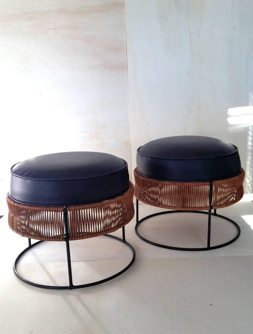 A pair of Arthur Umanoff cane wrapped wrought iron ring style tables / ottomans / stools manufactured by the Howard Shaver of Greensboro, N. C. in the mid 1960s. 

The continuous cane wrapping that covers the two upper rings makes a strong contrast