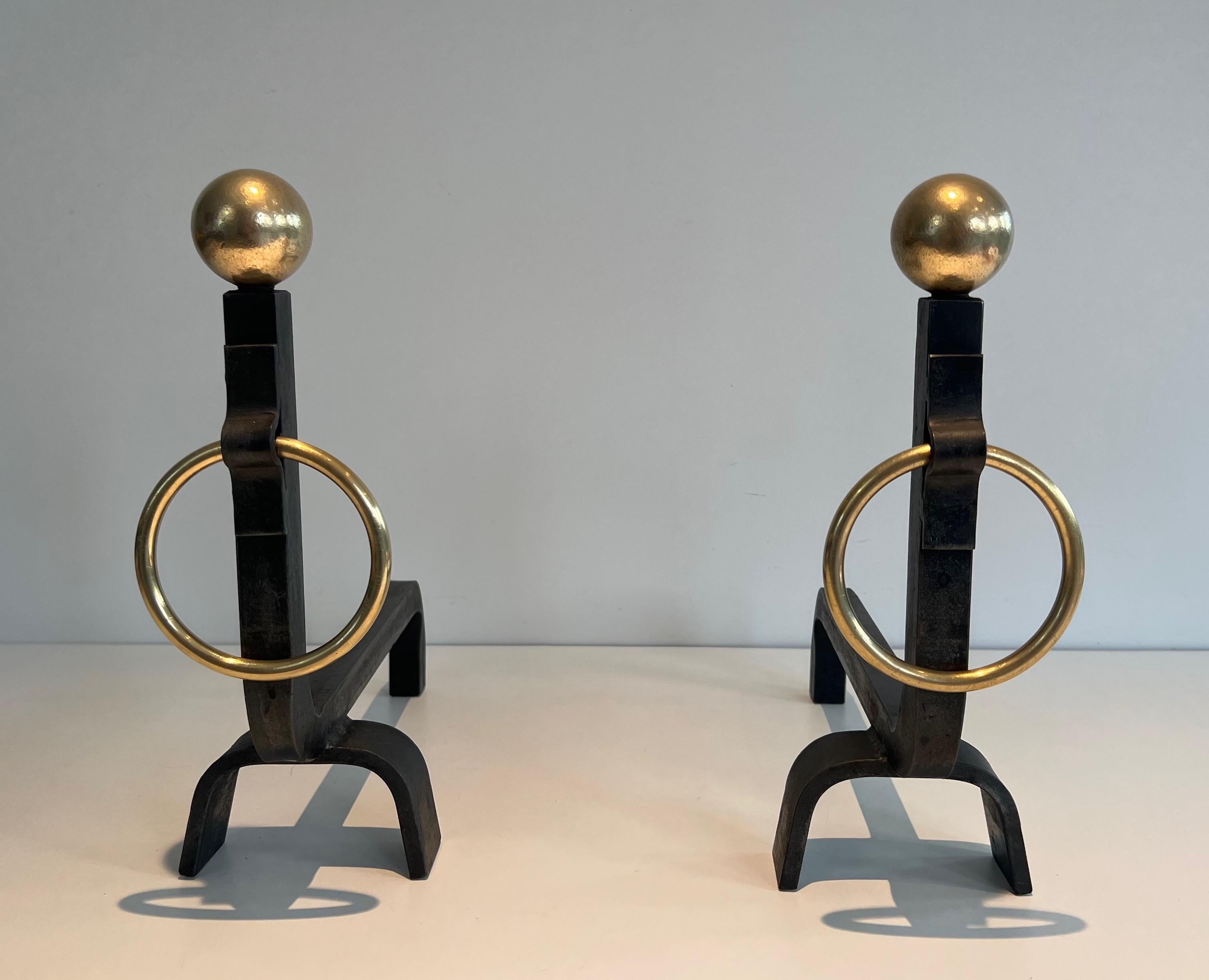 This very nice pair of andirons is made of wrought iron and brass. The quality of these andirons is very good and the design very stylished. This is a  French work in the style of Jacques Adnet. Circa 1950