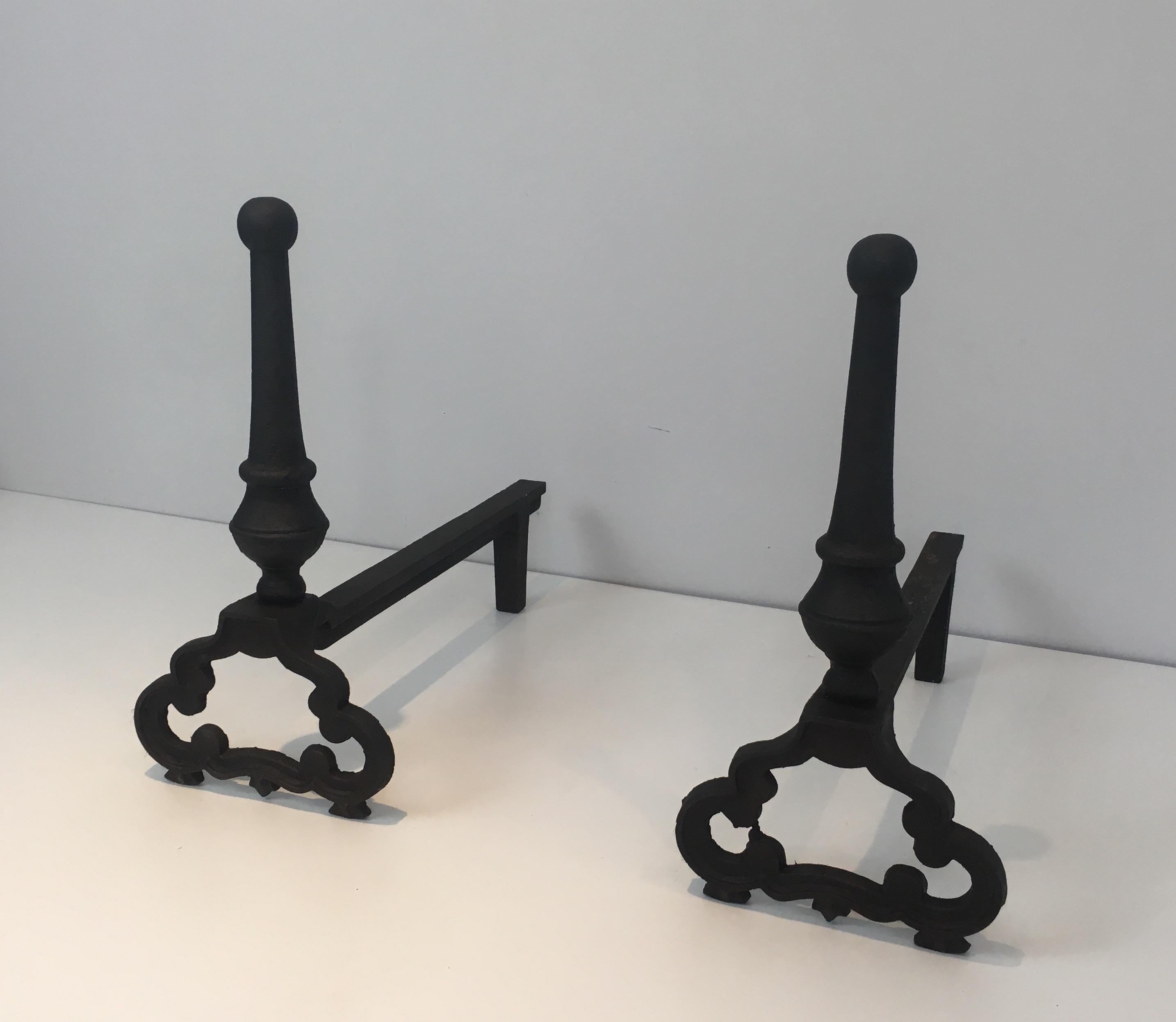 This pair of andirons is made of wrought iron and cast iron. This is a French work, circa 1940.