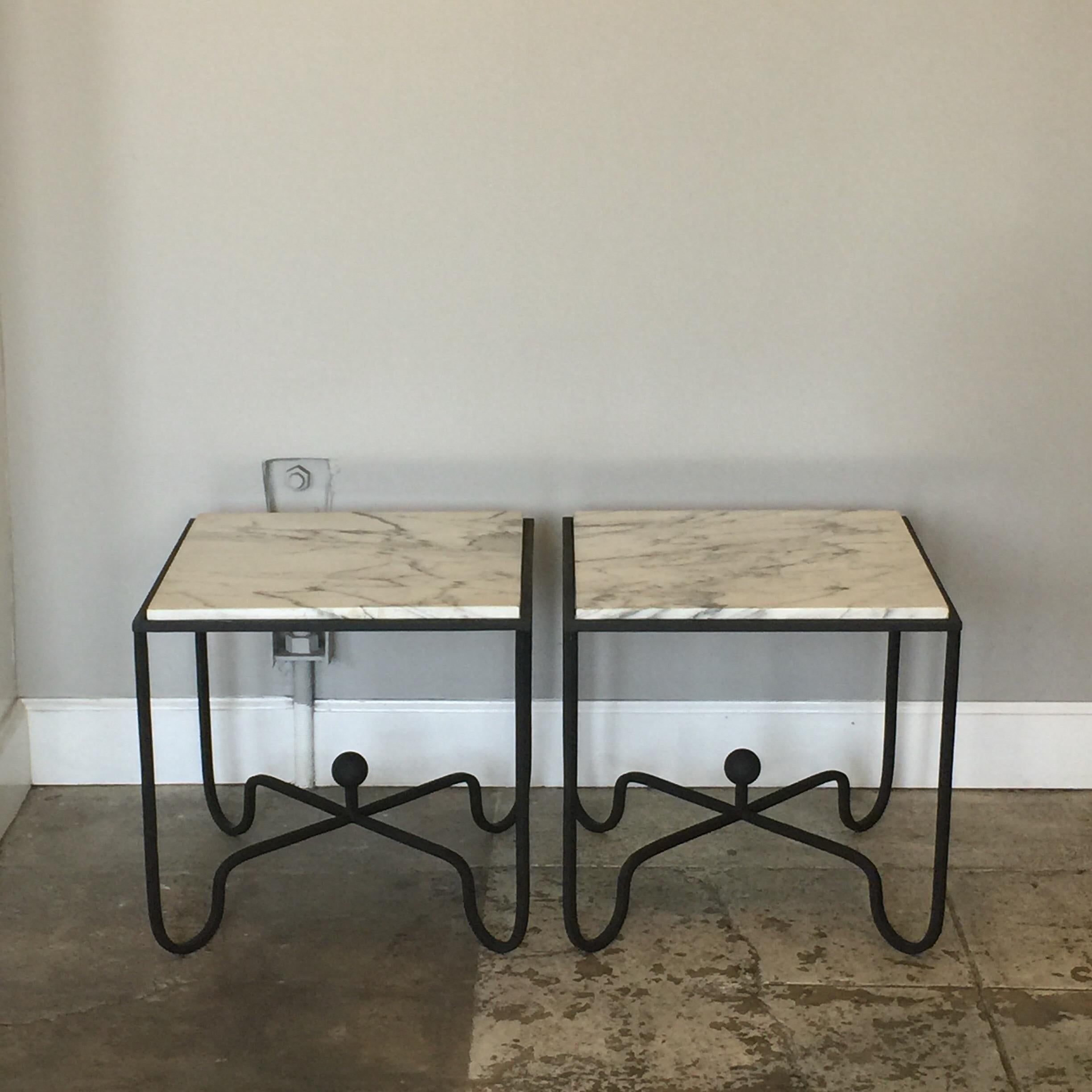 Paire de tables d'appoint 'Entretoise' en fer forgé et marbre de Design Frères. Des bases en fer forgé noir mat et des plateaux en marbre blanc veiné poli.