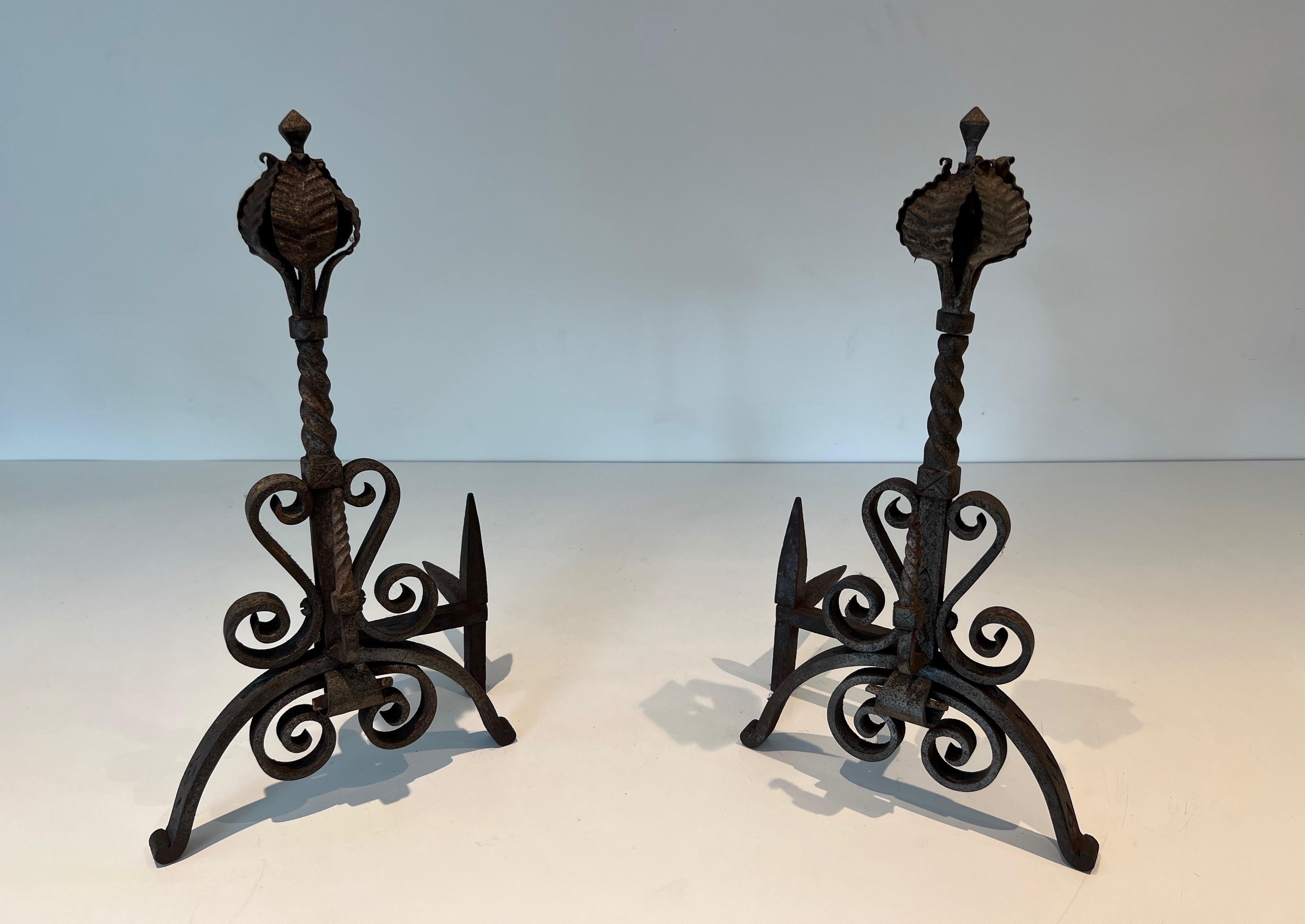 This pair of andirons is made of wrought iron. These firedogs are decorated with foliage and scrolls. This is a French work. Circa 1900