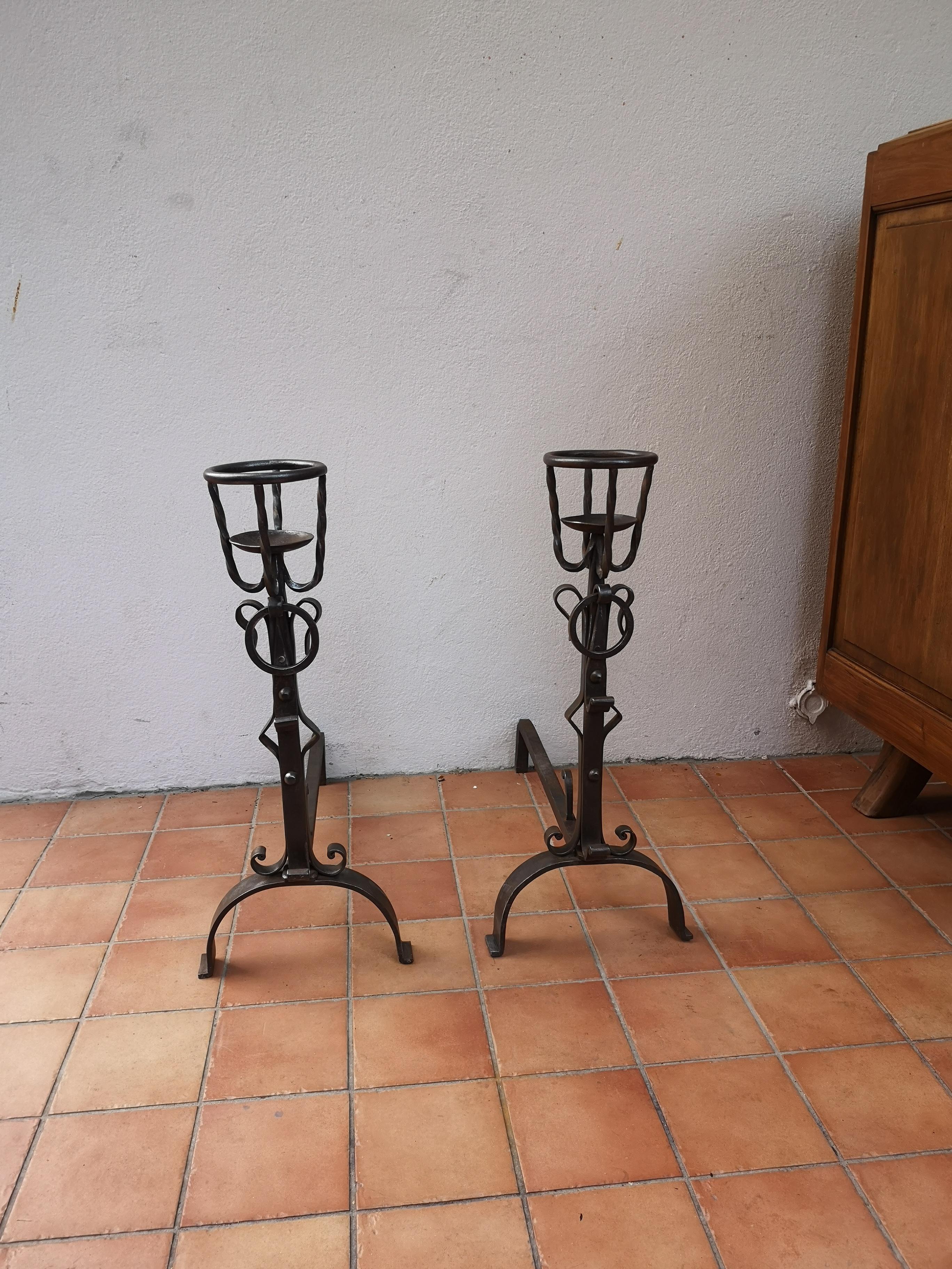 **For Sale: Antique Pair of Wrought Iron Andirons**

Discover this stunning pair of wrought iron andirons, also known as firedogs with bowl cups. These authentic and historical pieces will bring a touch of charm and elegance to your home.

Crafted