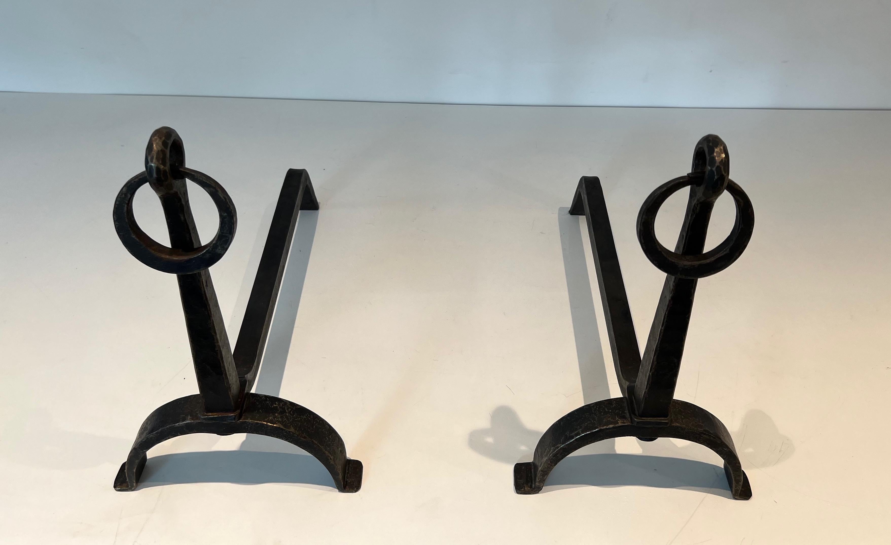 This pair of andirons is made of hammered wrought iron. This is a fine French Work in the style of Jacques Adnet. Circa 1920