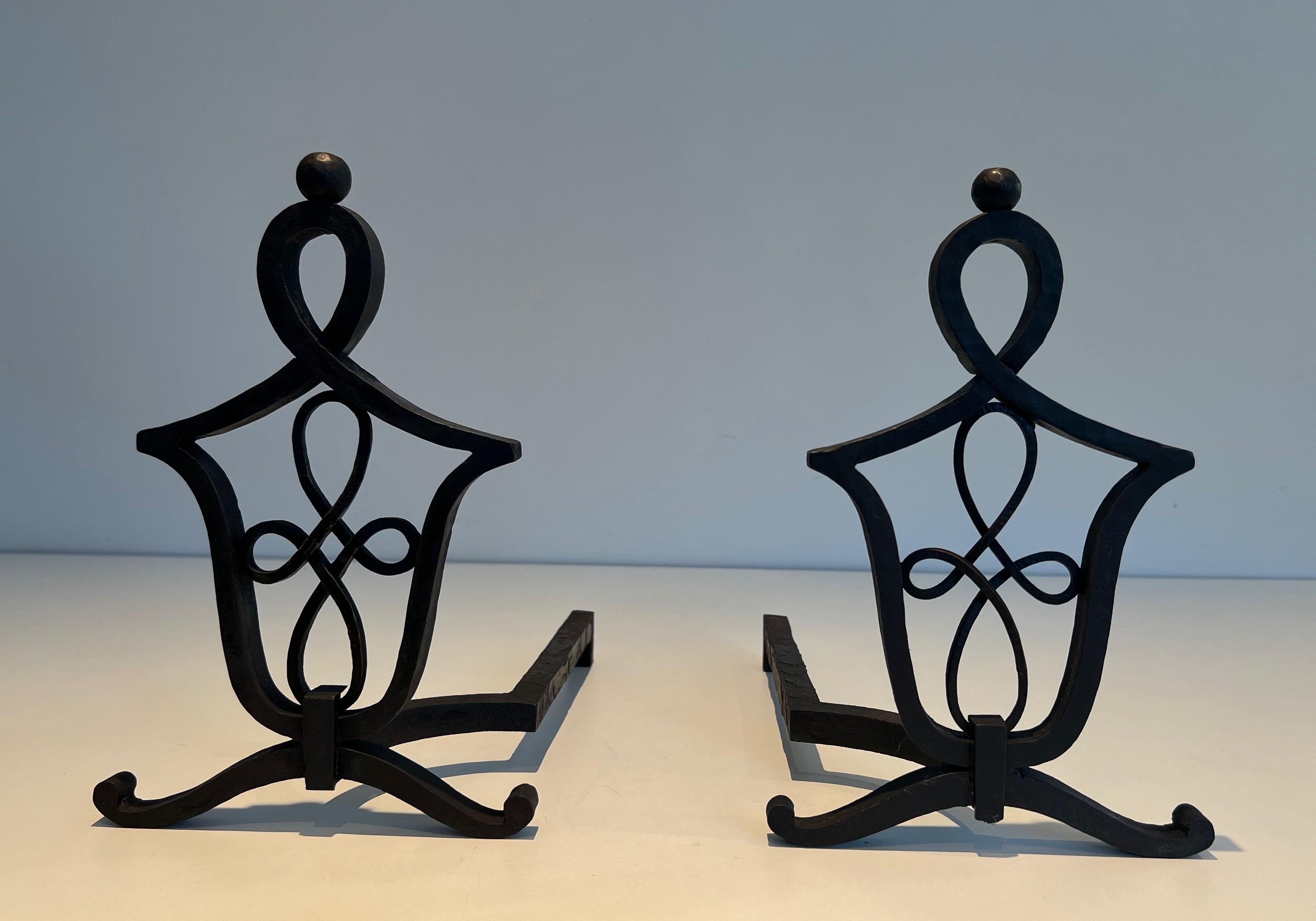 This pair of andirons is made of wrought iron. This is a very fine work in the style of famous French designer and wrought iron maker Raymond Subes. Circa 1940.