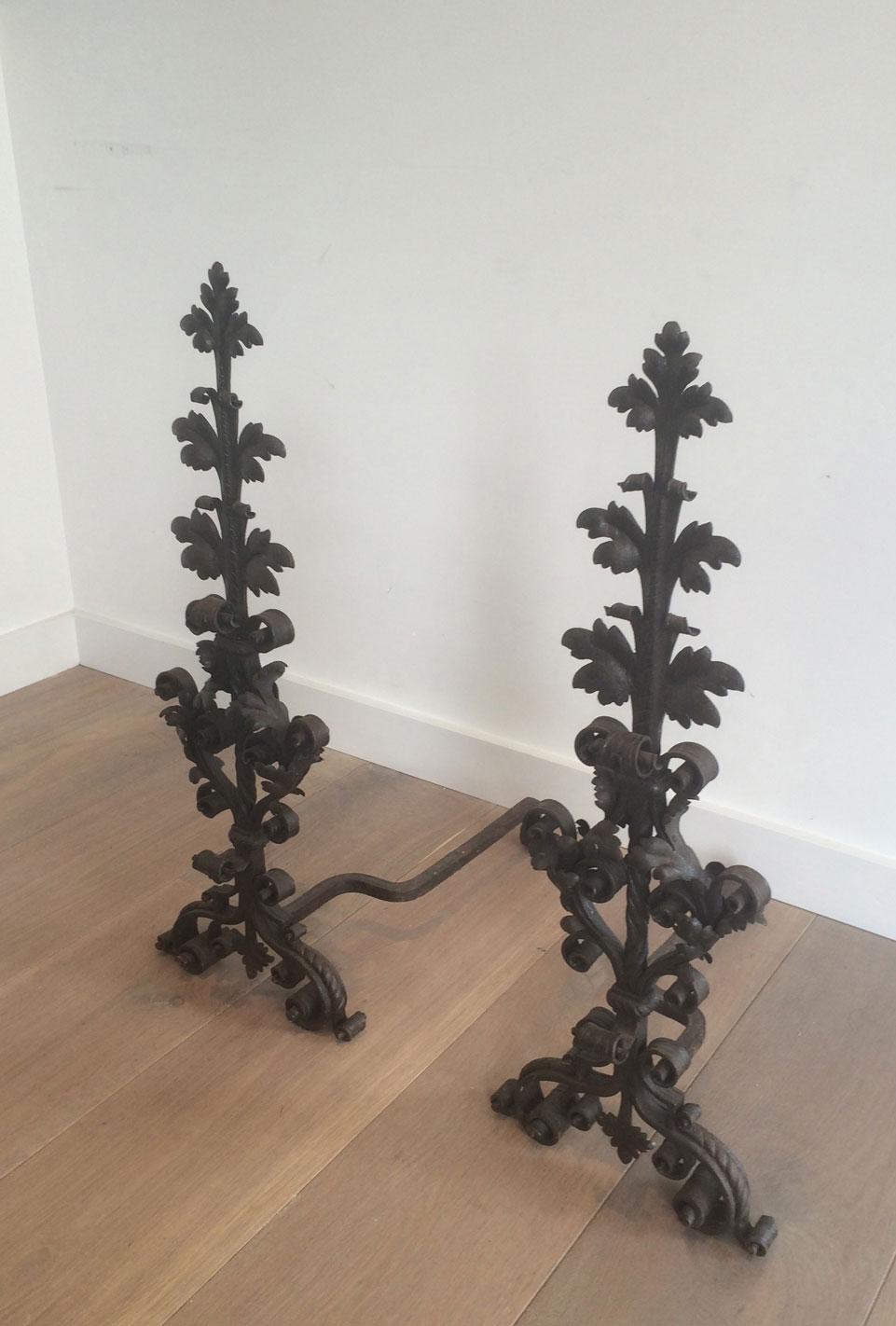 This beautiful pair of wrought iron andirons is made of worked iron oak leaves, twisted iron pieces. This is a very fine work. Amazing quality. These andirons are French and have been made by a wrought iron master. They are from 19th century.