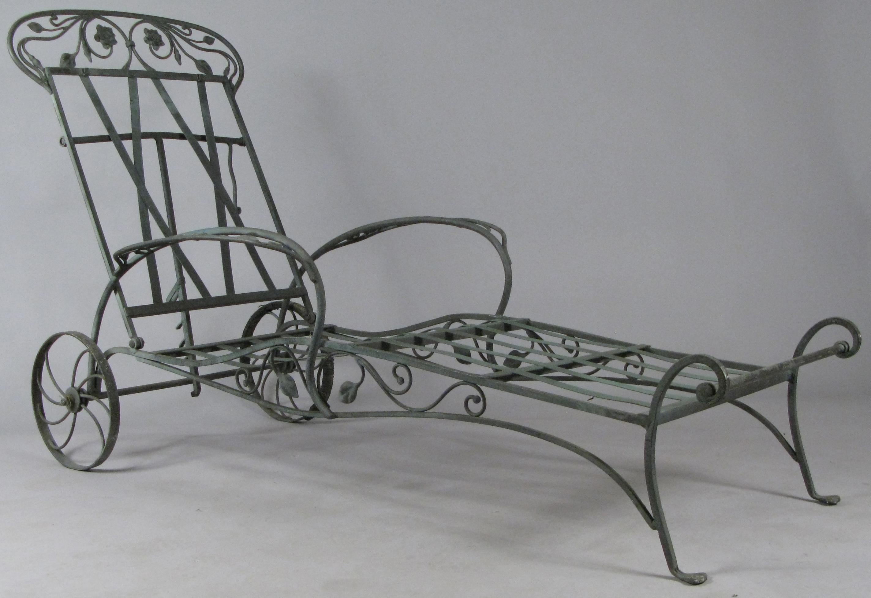 A very well made pair of wrought iron adjustable chaise lounges, made by Salterini, circa 1950, in their blooming rose pattern. Beautifully designed and made, with vine and flower details under the skirt and above the back, and with lovely scrolled
