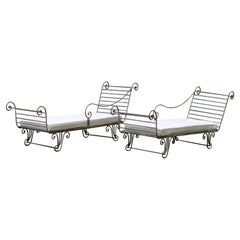 Paire de chaises en fer forgé avec coussins recouverts de parapluies