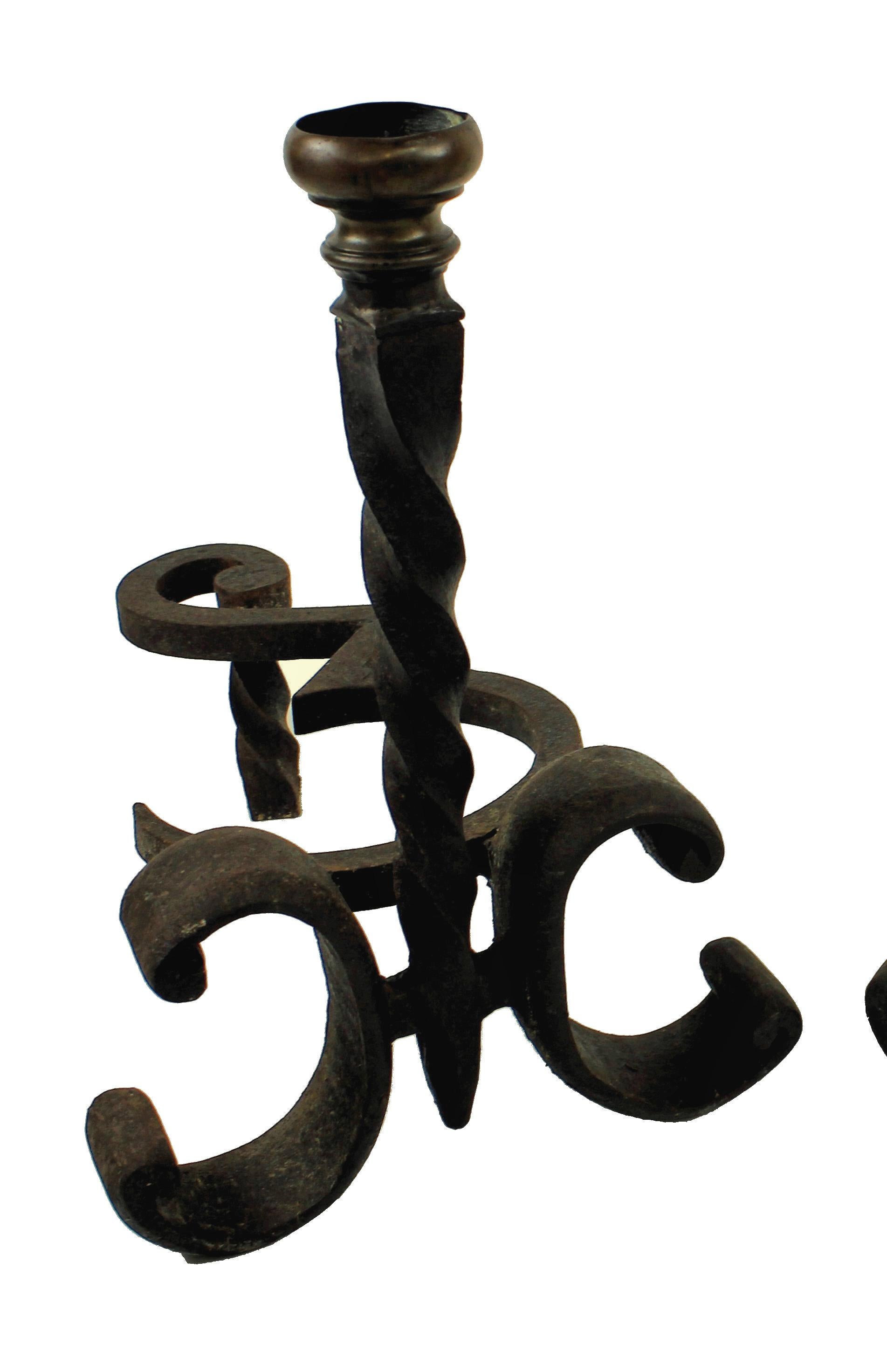 A pair of French Chenet (fire dogs) in wrought iron with a brass finial.