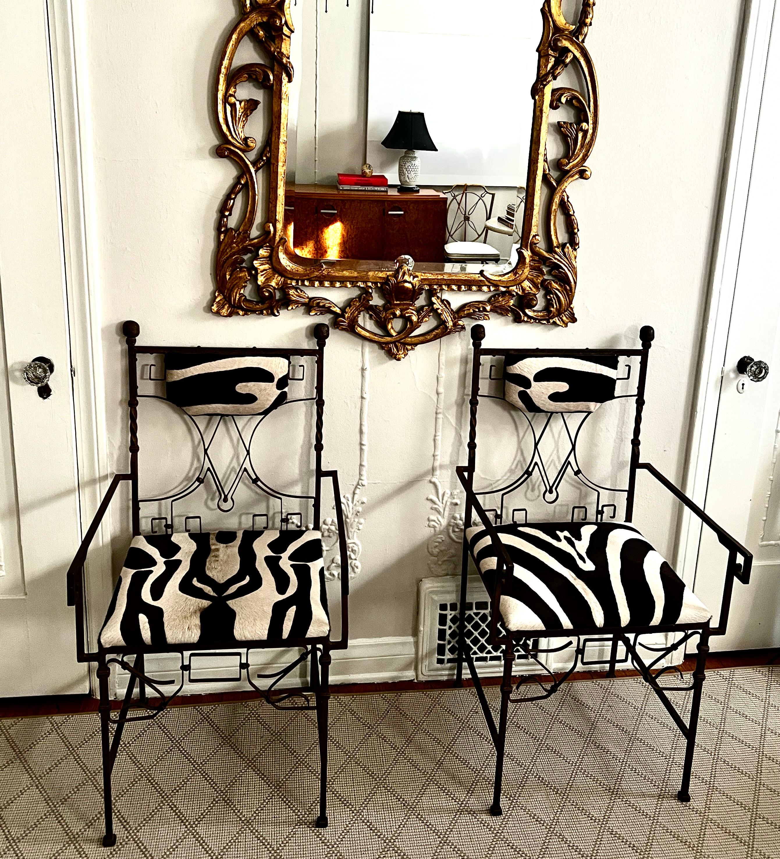 Ein exquisites Paar wunderschön gestalteter französischer Art-Déco-Stühle aus Schmiedeeisen, gepolstert mit Kuhfell mit Zebradruck.

Verwenden Sie das Paar als Kunstwerk, das einen Eingang flankiert, in einem Ess- oder Frühstückszimmer.  Das Zebra