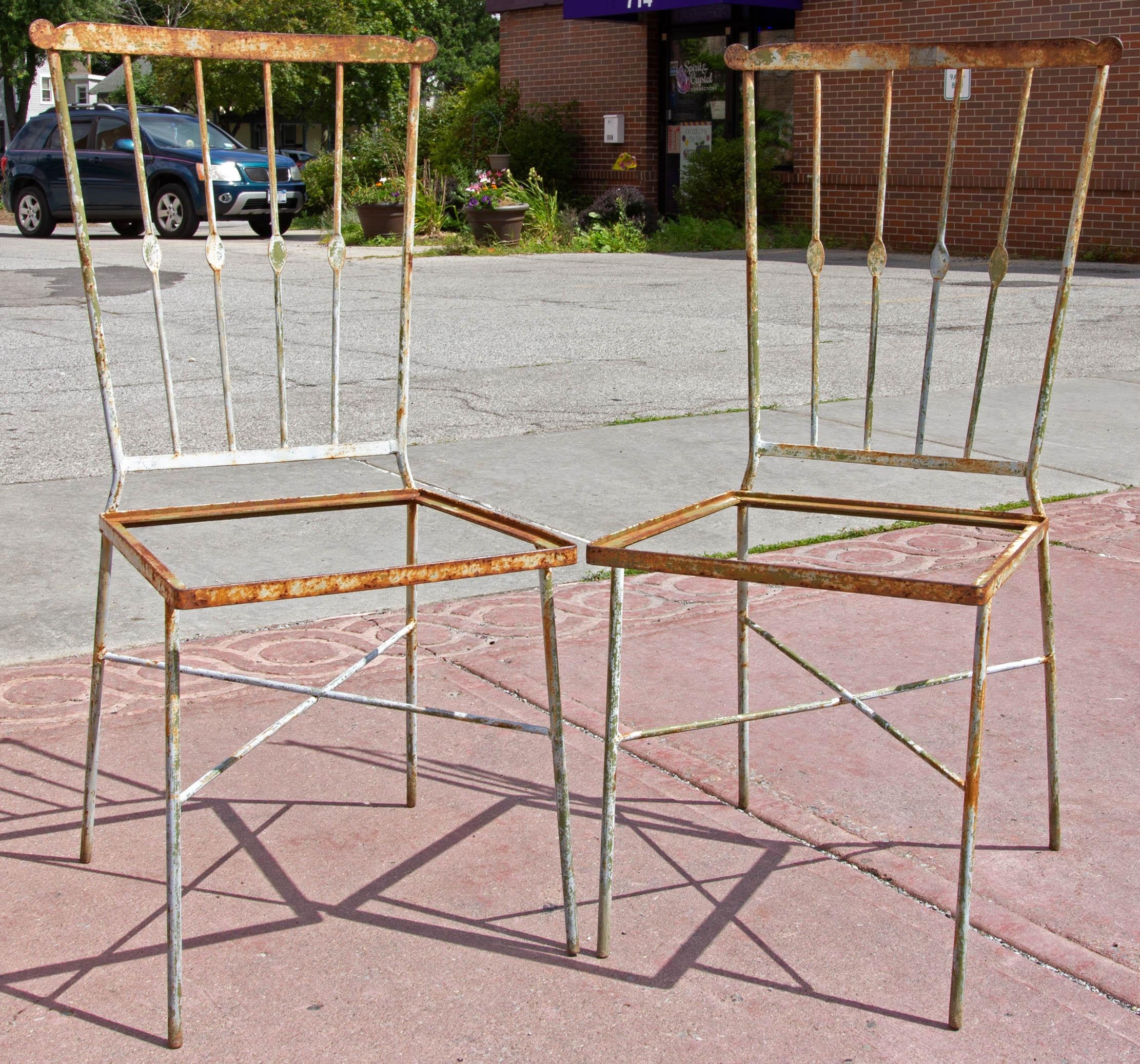 Wrought iron garden chairs with stylized Windsor chair backs. In nice weathered condition, circa 1920s.