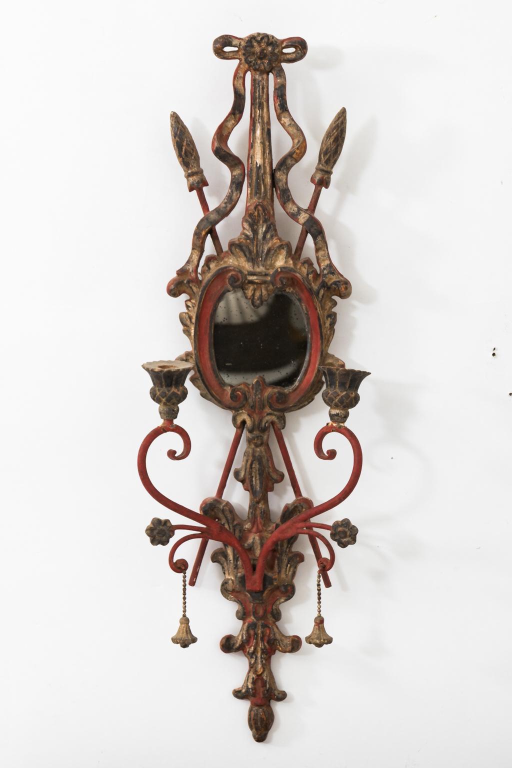 Pair of Italian wrought iron gilded sconces in a red painted finish. The sconces also feature mirrored backs and two arms for candles, circa 1930-1950.
 