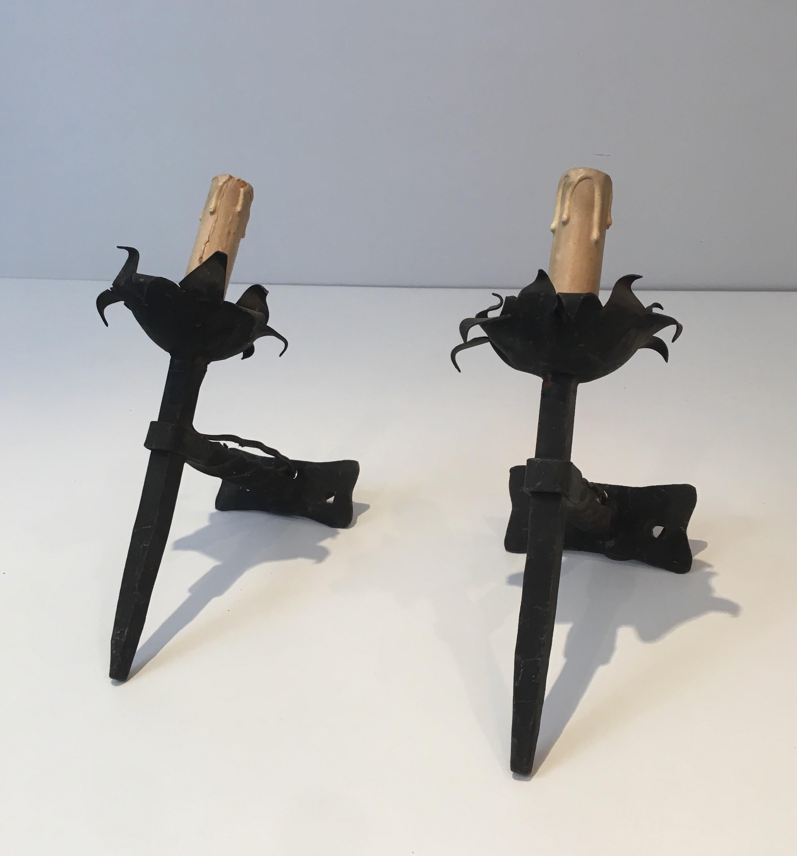 This pair of wall sconces is made of wrought iron. These wall lights were made in France, circa 1940.