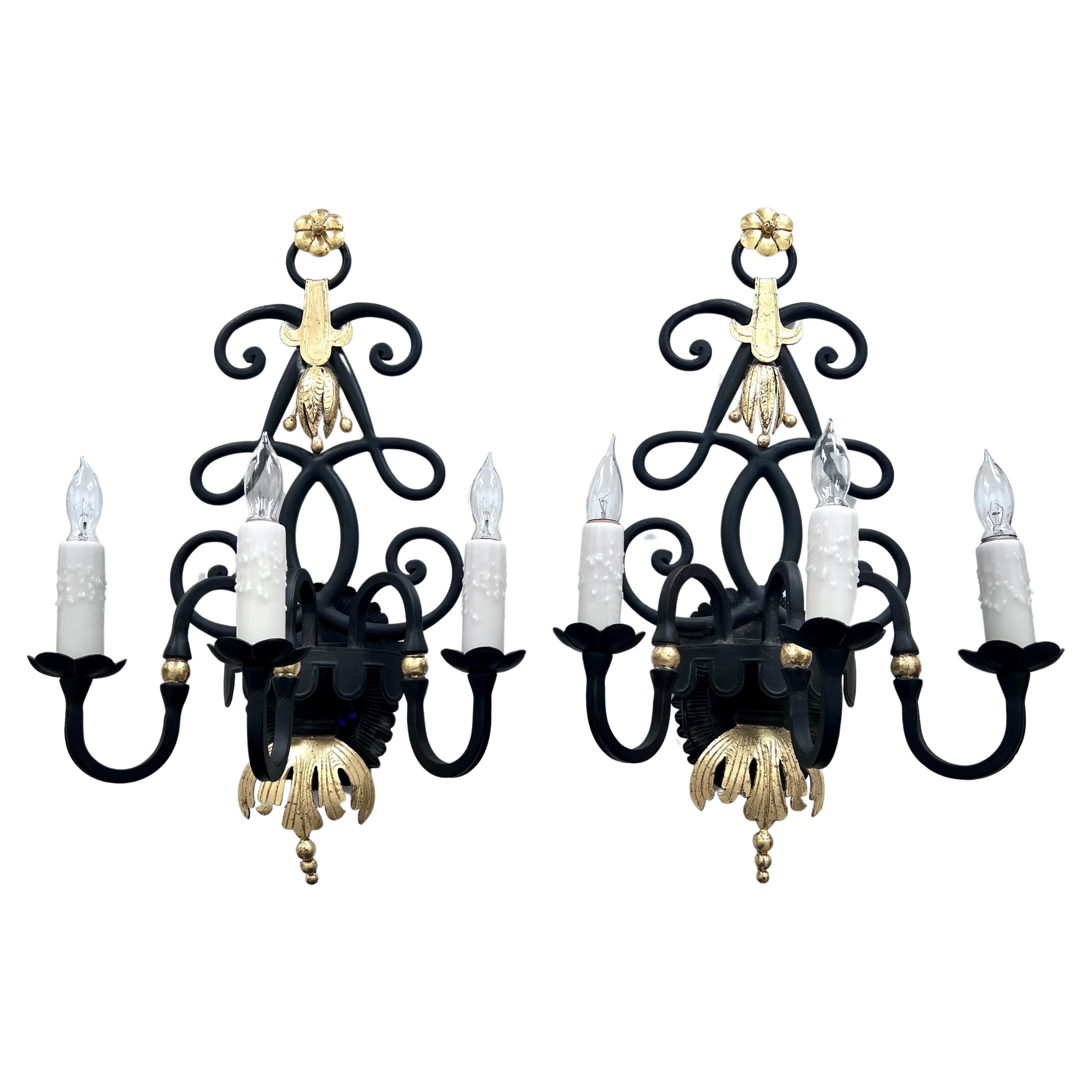A stunning pair of Wrought Iron wall Sconces in the style of Rene Drouet and Gilbert Poillerat - the pair are hand wrought with burnished 24k Gold to the details - each holds three stand socket Chandelier light bulbs.

The Art Deco look is very