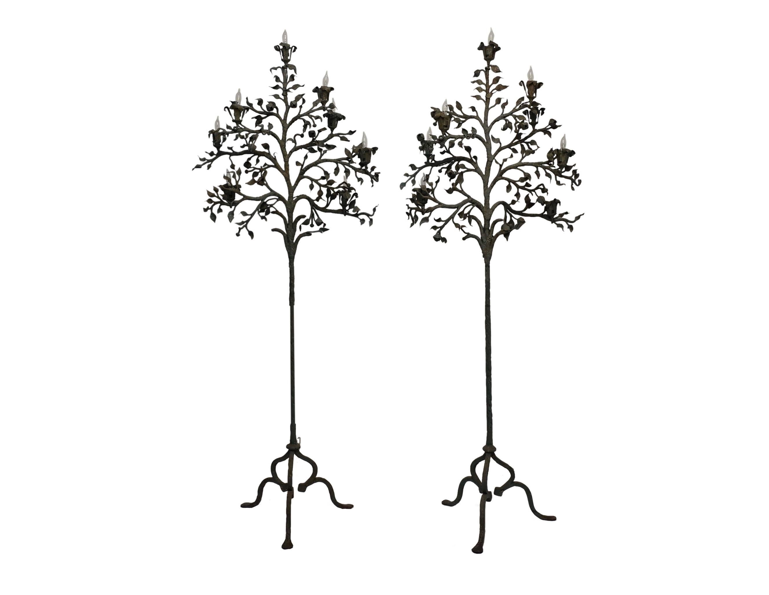 A pair of wrought iron tree shape eight light candle torchieres standing on try pad feet and painted a soft green color. Recently re-wired for lights, holding chandelier base bulbs, Italy, mid-19th century.