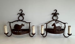 Pair of wrought iron wall lights showing animals. French work. Circa 1950