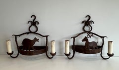 Pair of wrought iron wall lights showing animals. French work. Circa 1950