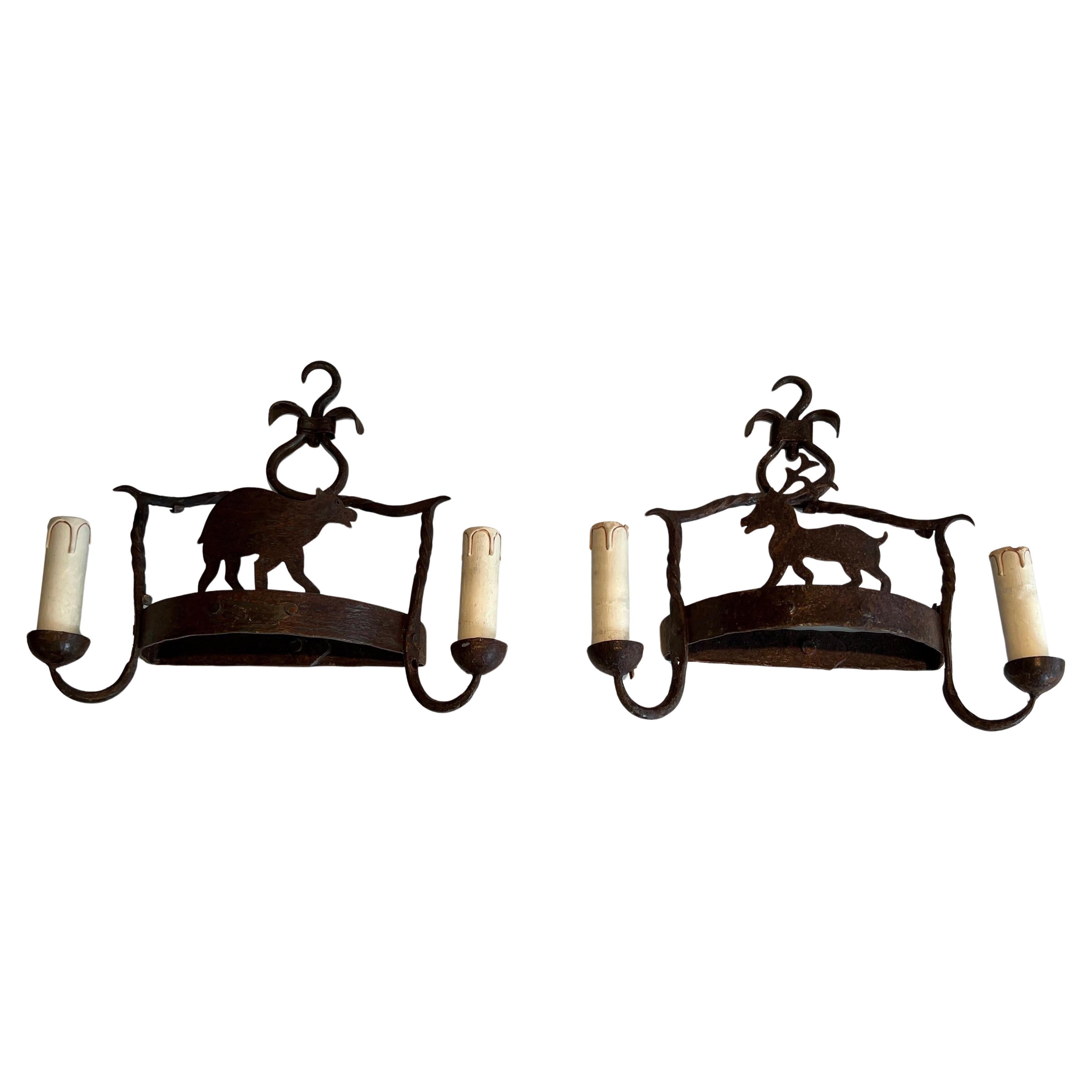 Pair of wrought iron wall lights showing animals. French work. Circa 1950 For Sale