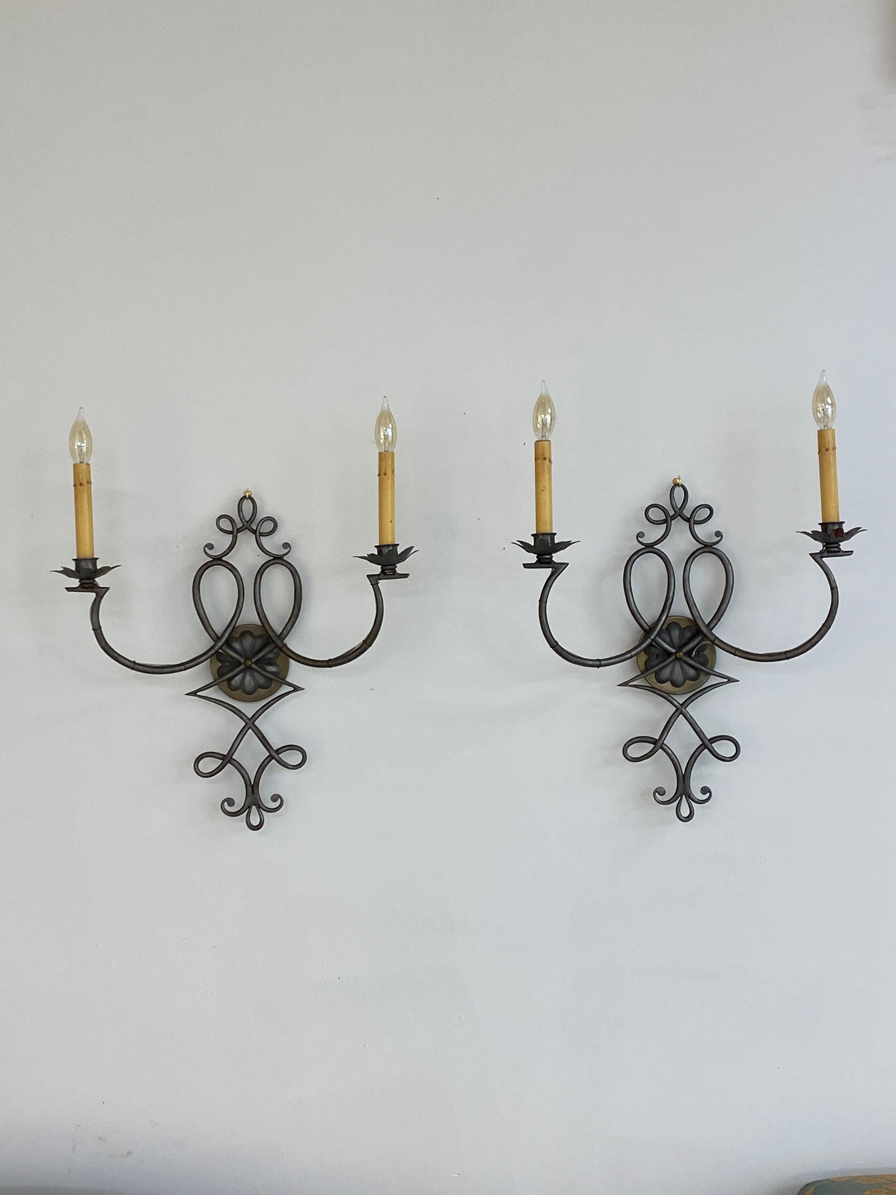 Pair of two light polished wrought iron wall scones in the Art Deco style of Jules Leleu. 

Measures: 19.5