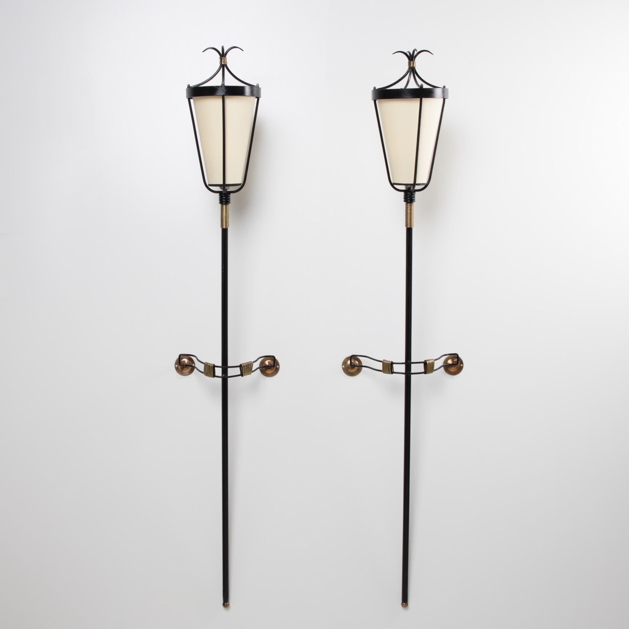 Spectacular pair of wall lights.
Work of an Art ironworker, these wrought iron sconces are composed of a long central shaft supporting a lampshade whose uprights end in a crown.
The wall brackets are equipped with brass screws, brass which is also